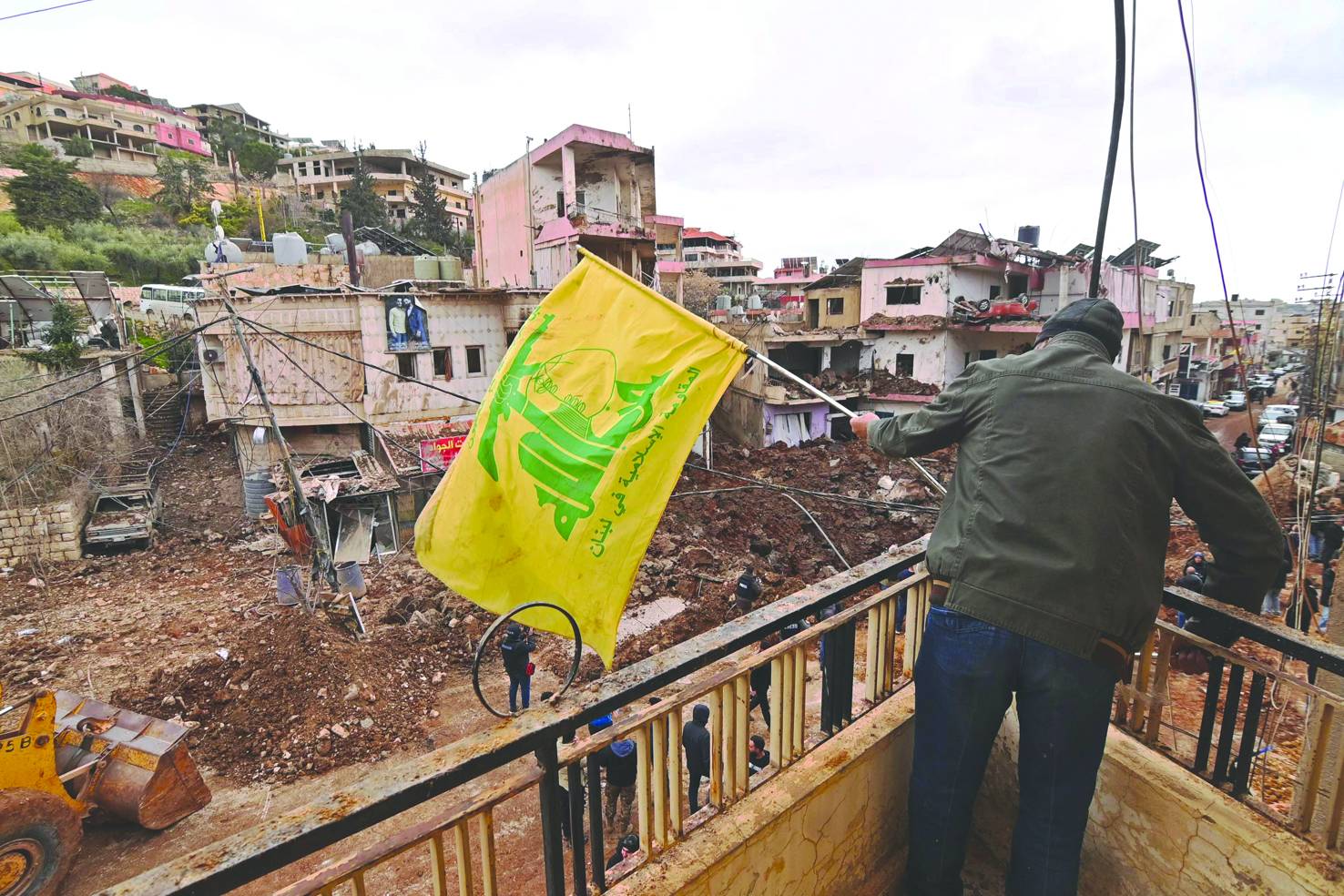 İsrail ordusunun bir çıkarma operasyonu düzenleyerek kasabayı yoğun bombardıman altında tuttuğu ve onlarca kişinin ölümüne ve yaralanmasına neden olduğu Lübnan’ın doğusundaki Nebi Şit kasabasında Hizbullah bayrağı sallayan Lübnanlı bir vatandaş (AFP)