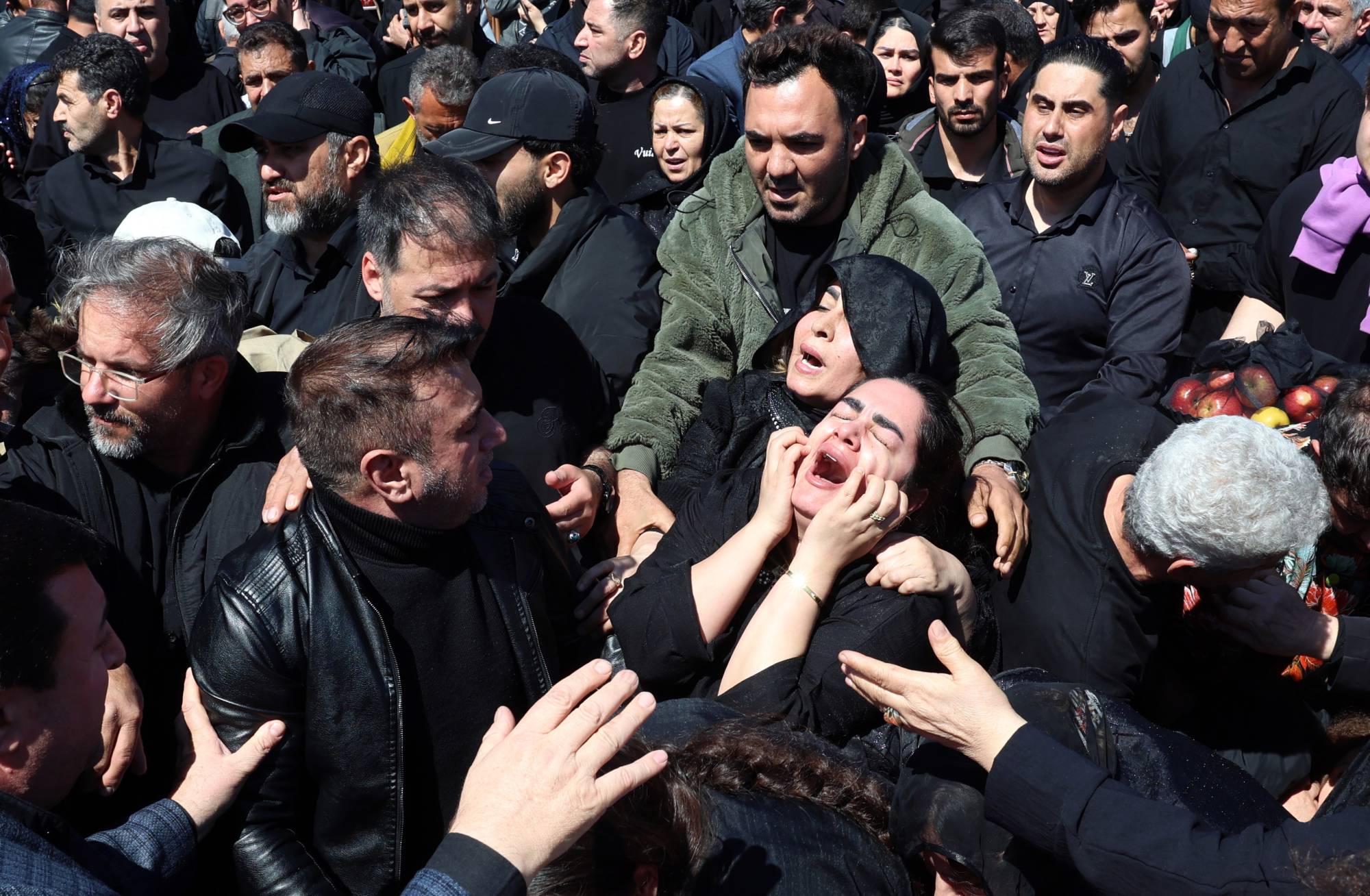 Tahran'da bir savaş kurbanının cenazesinde yas tutan İranlılar (EPA)