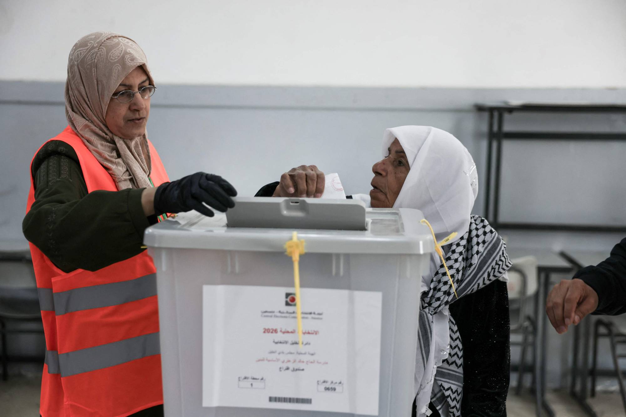 Filistinli bir kadın, Batı Şeria'daki Hebron kentinde düzenlenen yerel seçimler sırasında bir sandıkta oyunu kullandı (AFP)