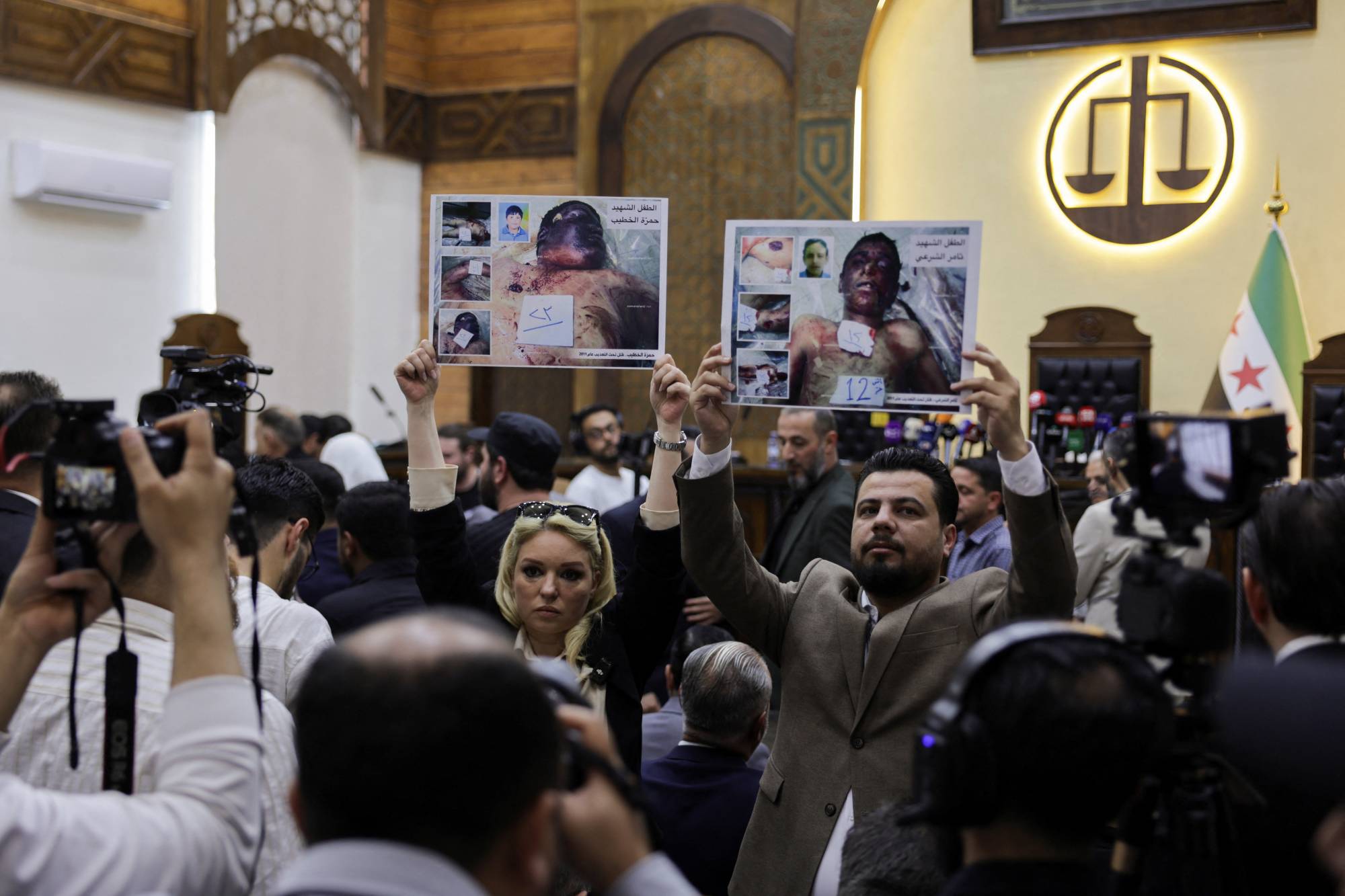 Protestocular, 26 Nisan 2026'da Şam'daki Adalet Sarayı'nda Atıf Necib'in yargılandığı gün pankartlar açtı (Reuters).