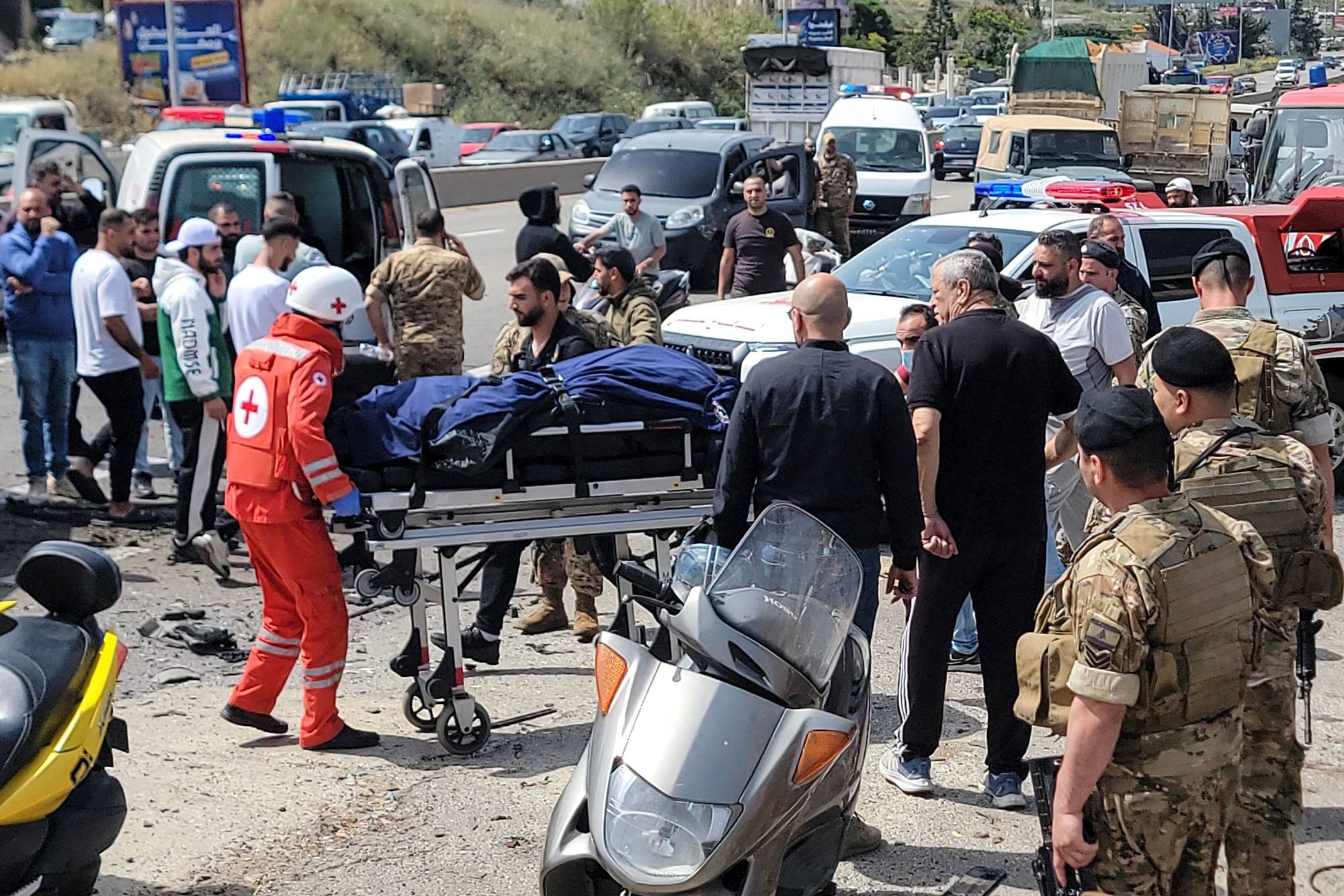 Kurtarma ekipleri, Beyrut'un güneyindeki Ciye kasabasında bir aracı hedef alan İsrail hava saldırısının ardından olay yerinde kurbanlardan birinin cesedini taşıyor (AFP)