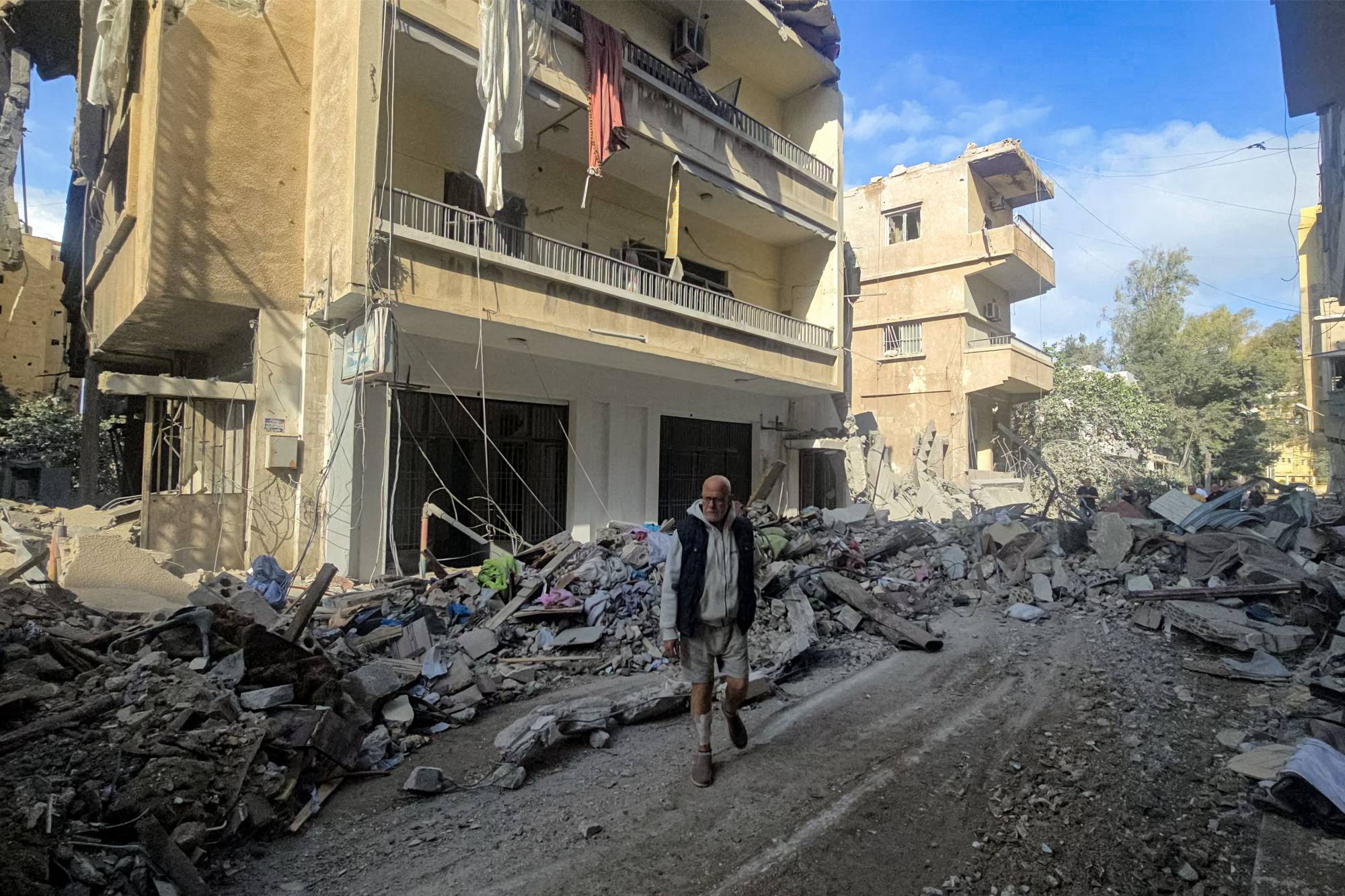 Vatandaşlar, İsrail bombardımanı sonucu Sur’daki bazı binalarda meydana gelen hasarı inceliyor. (AFP)
