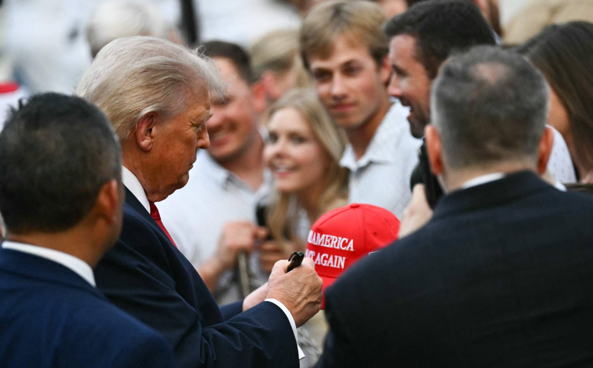 Trump, Beyaz Saray’da MAGA şapkalarını imzalarken, 19 Mayıs 2026 (AFP)
