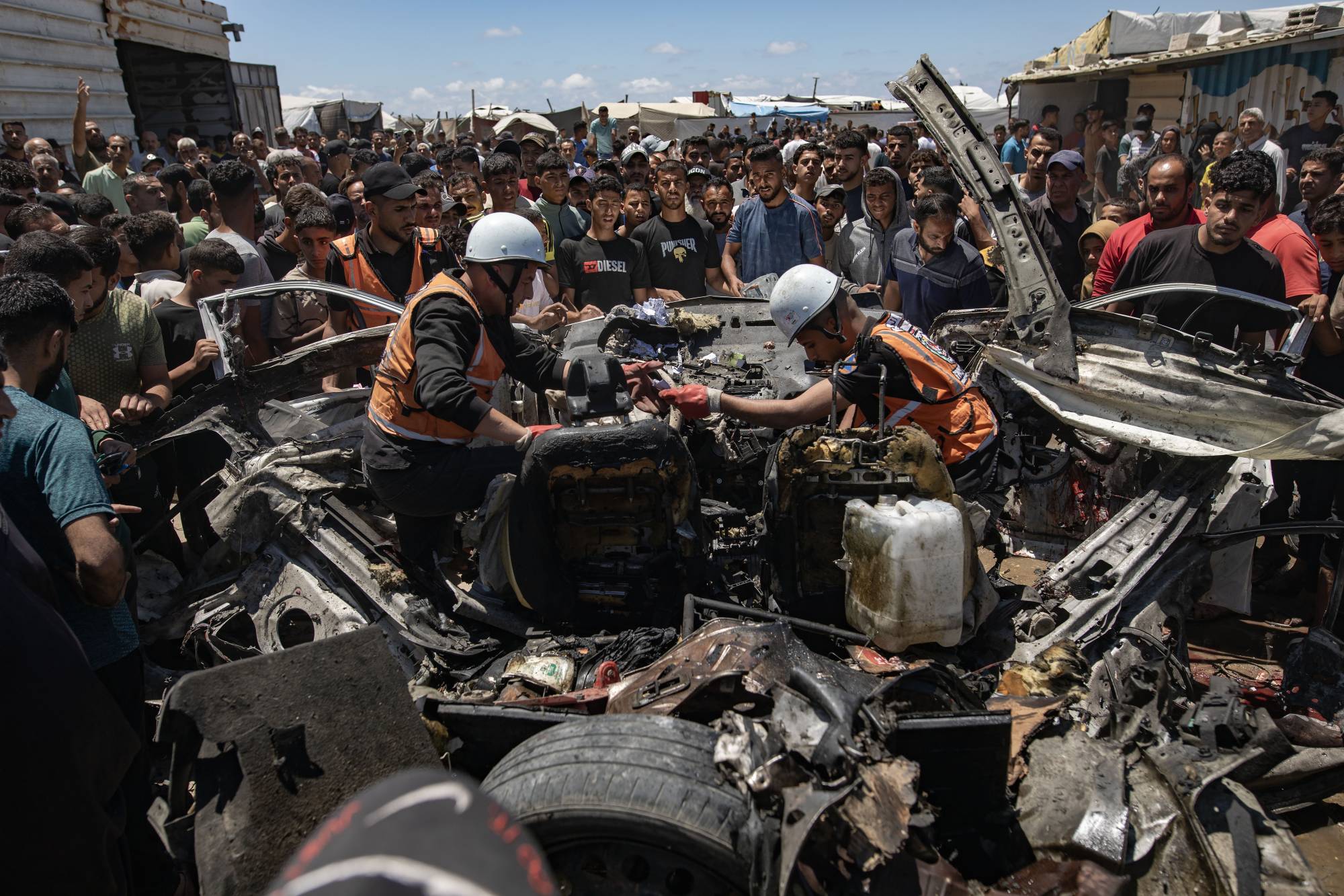 Dün İsrail’in Gazze'nin güneyindeki Han Yunus kentinde düzenlediği hava saldırısında hedef alınan aracın enkazını inceleyen Filistin sivil savunma ekipleri (EPA)