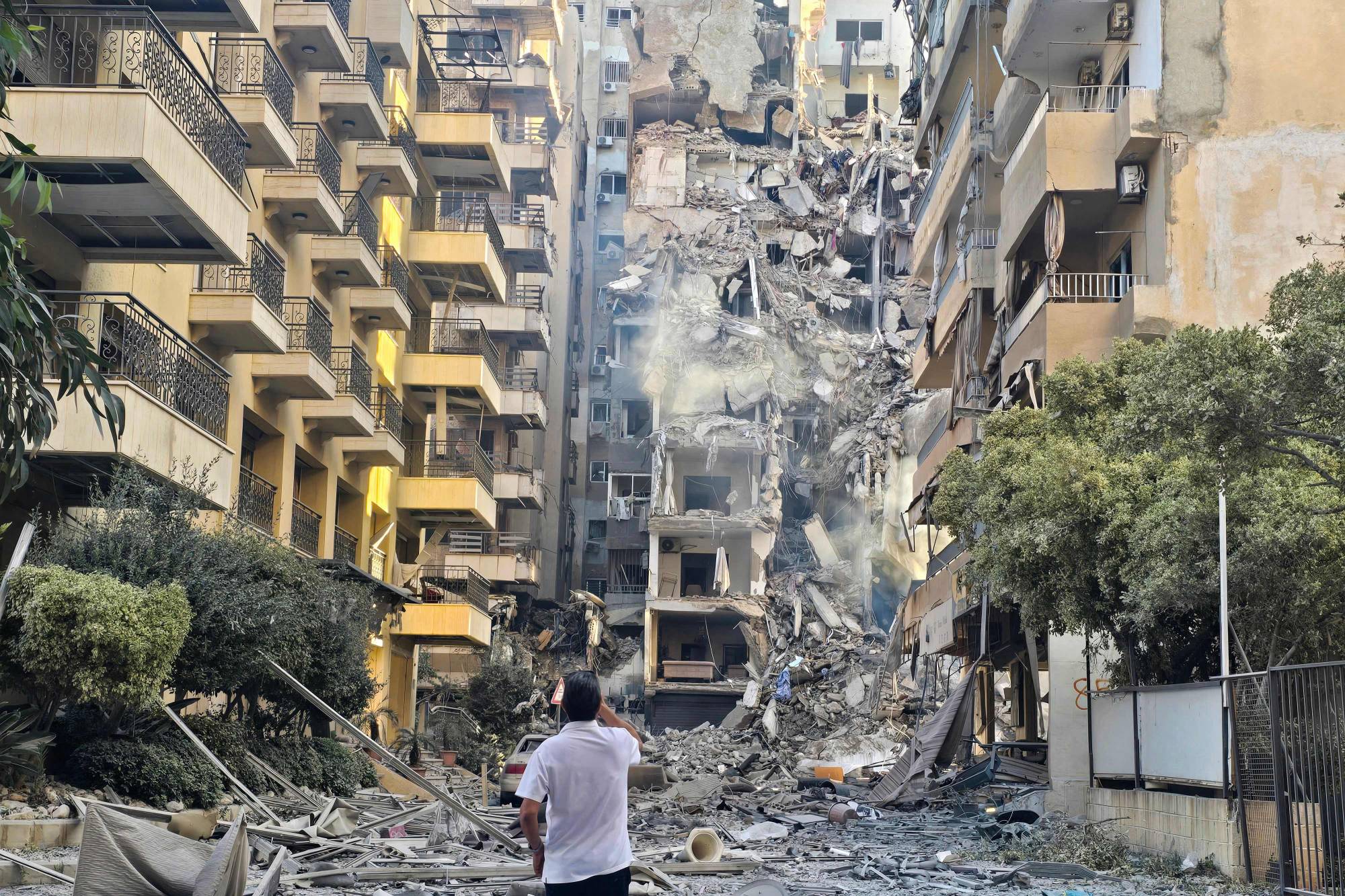  Lübnan’ın güneyindeki Sur kentinde İsrail hava saldırısının yaşandığı bölgede meydana gelen hasarı inceleyen bir adam (AFP