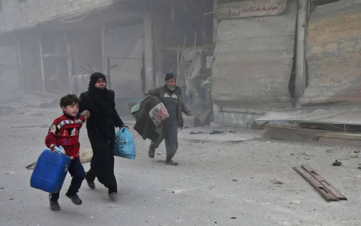 Suriye'nin doğusundaki Hamuriye kasabasının rejim güçleri tarafından bombalanmasından kaçan bir Suriyeli aile (Arşiv - AFP)