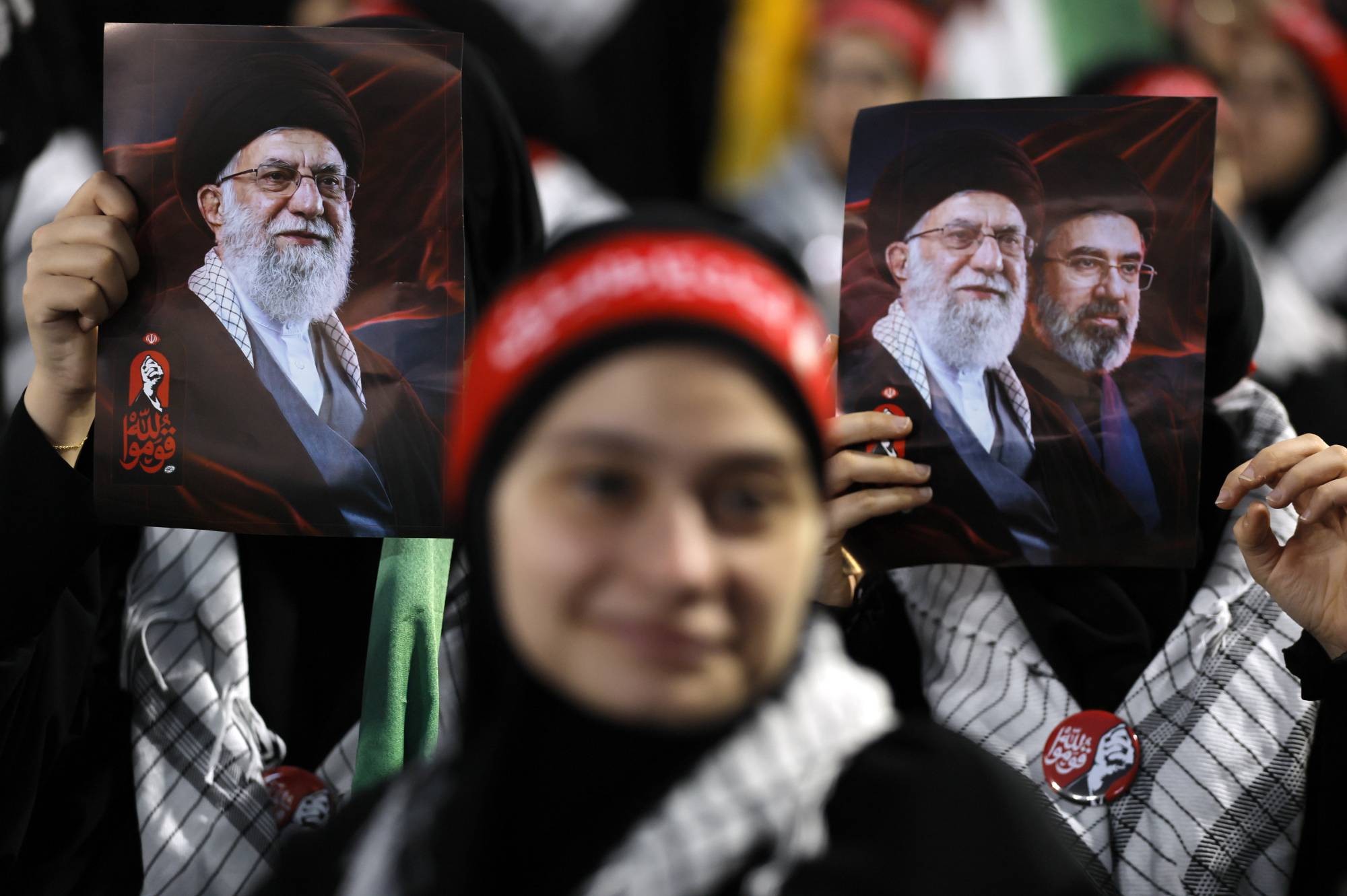 Hizbullah destekçisi bir kadın, İran'da eski Dini Lider Ali Hamaney için düzenlenen cenaze töreni etkinlikleriyle eş zamanlı olarak Beyrut'un güney banliyösünde Hamaney'in fotoğrafını taşıyor. (EPA)