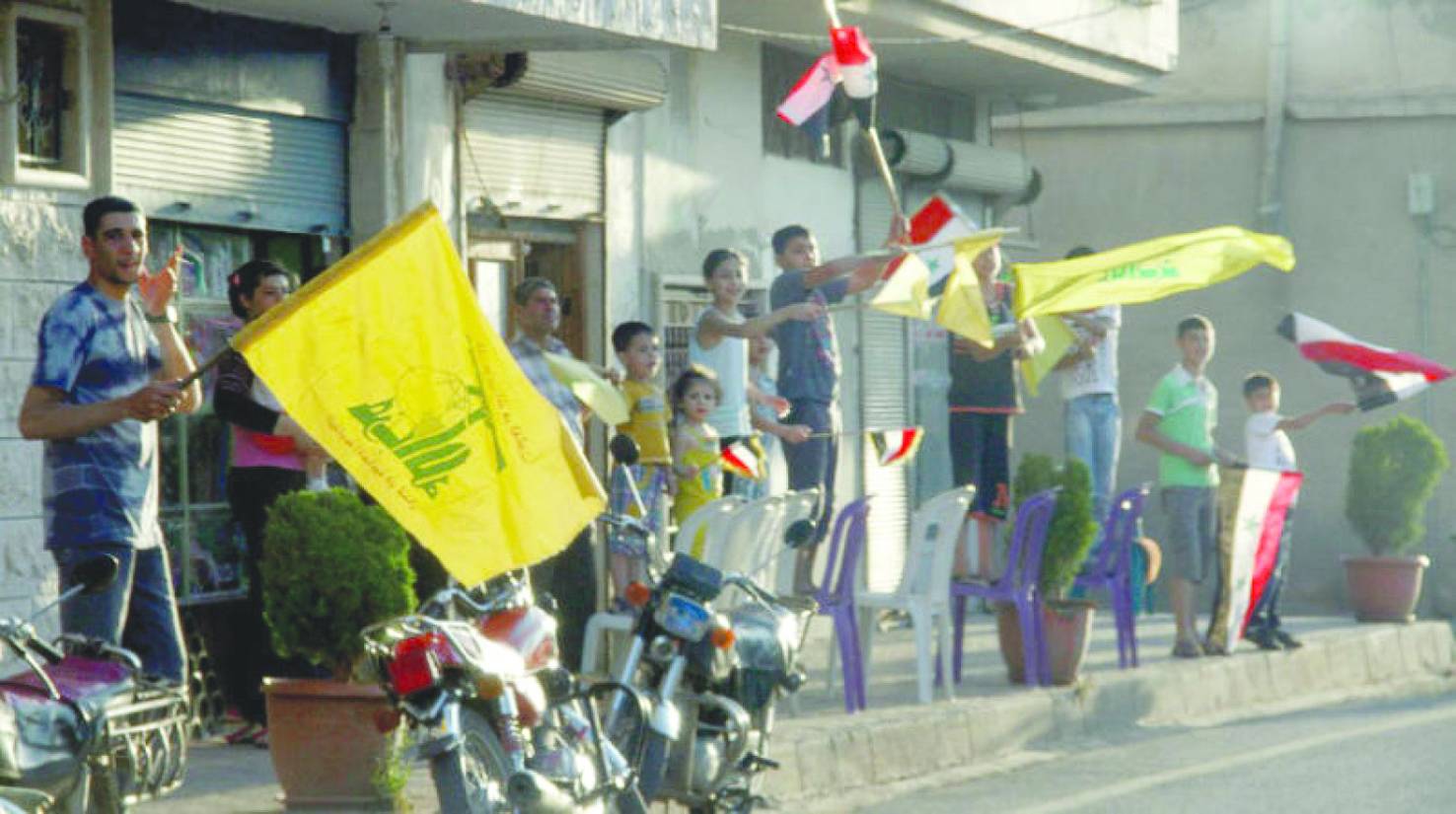 Suriye-Lübnan sınırındaki el-Kusayr kentinde dalgalanan Hizbullah bayrakları, Haziran 2013 (AFP)