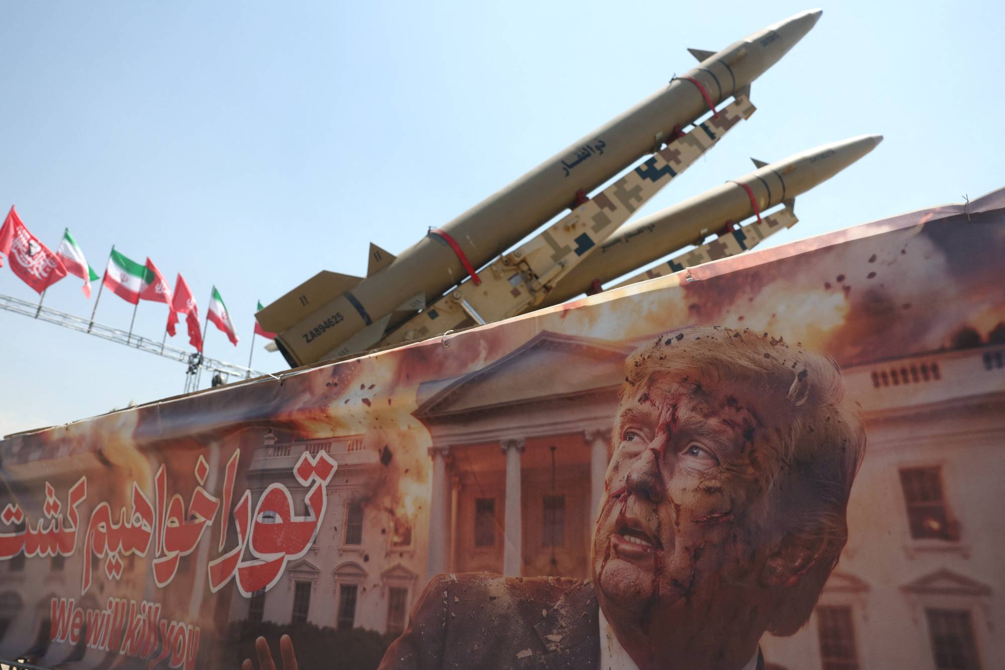 Tahran'daki Azadi Meydanı'nda, ABD Başkanı Donald Trump'ı tehdit eden bir pankart ile İran'a ait bir füze sistemi yan yana görüntülendi. (Perşembe / Reuters)