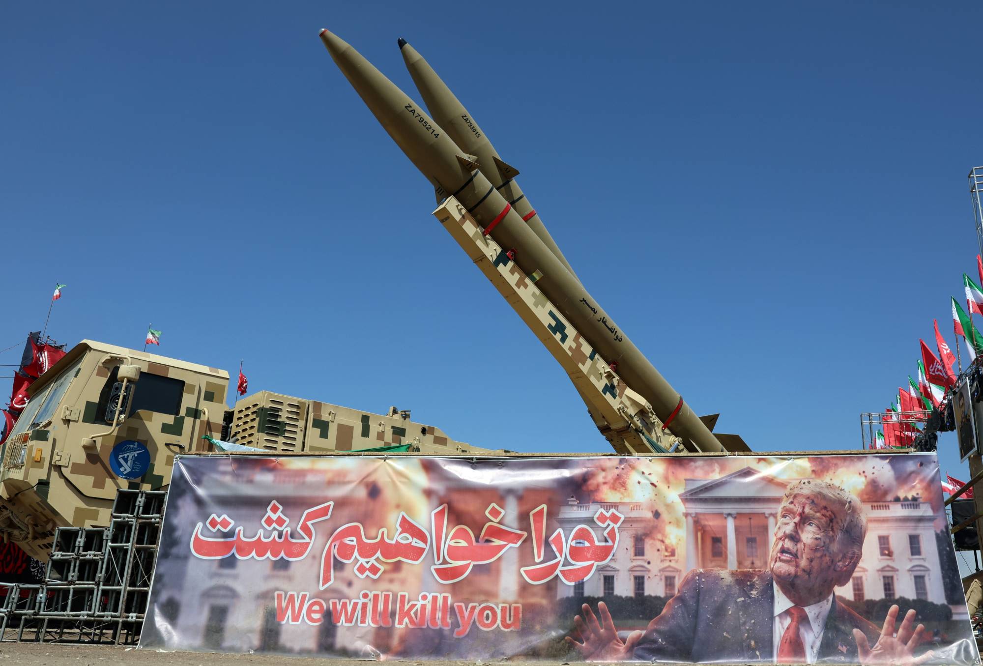 İran’ın başkenti Tahran’daki Azadi Meydanı’nda, ABD Başkanı Donald Trump’ı ölümle tehdit eden bir pankartın yanında İran füze sistemleri görülüyor. (Reuters)