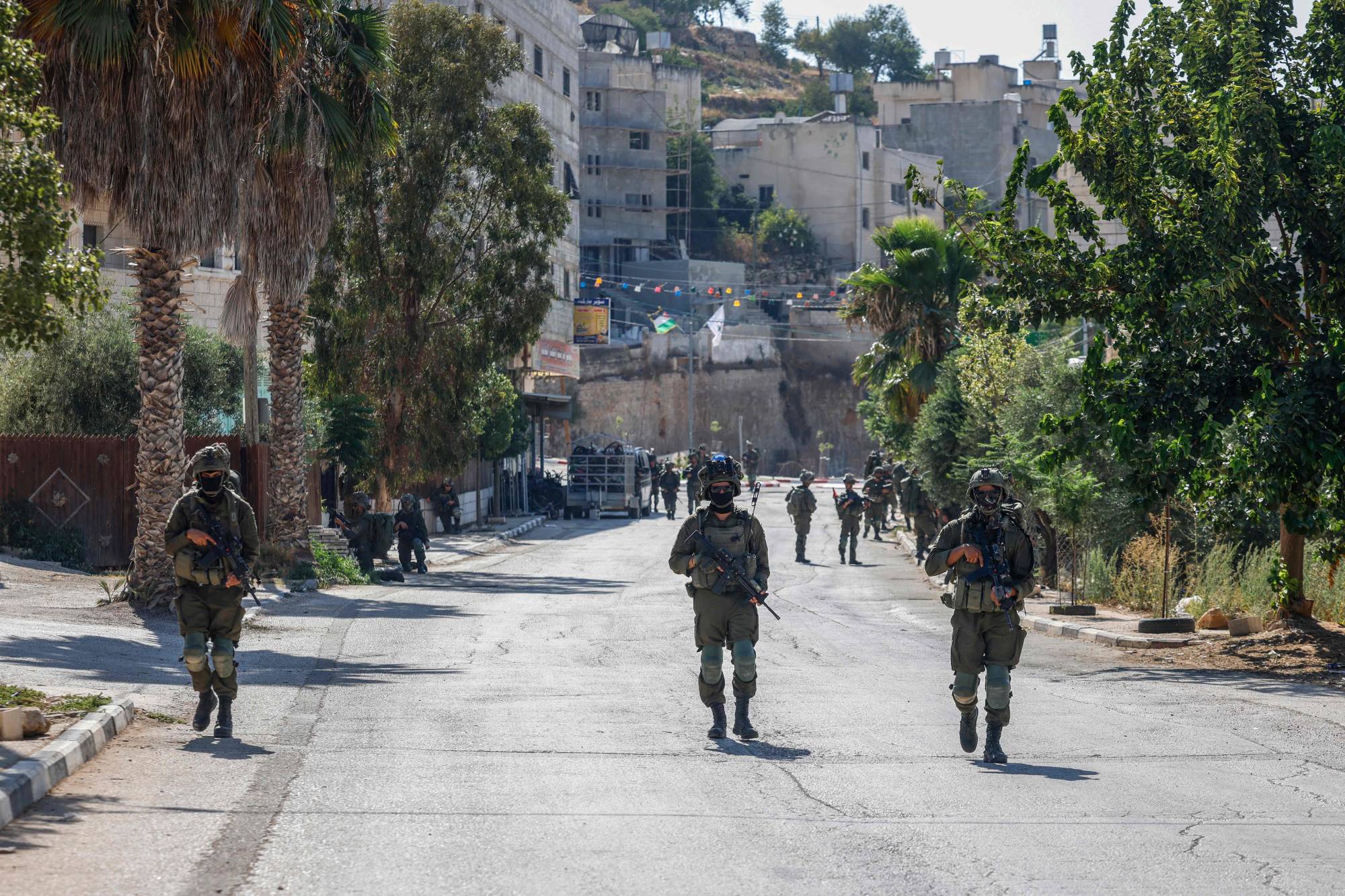 Geçtiğimiz perşembe günü, Batı Şeria’nın Nablus kentinin güneyindeki Kusra köyünün sokaklarından birinde devriye gezen İsrail askerleri (AFP)