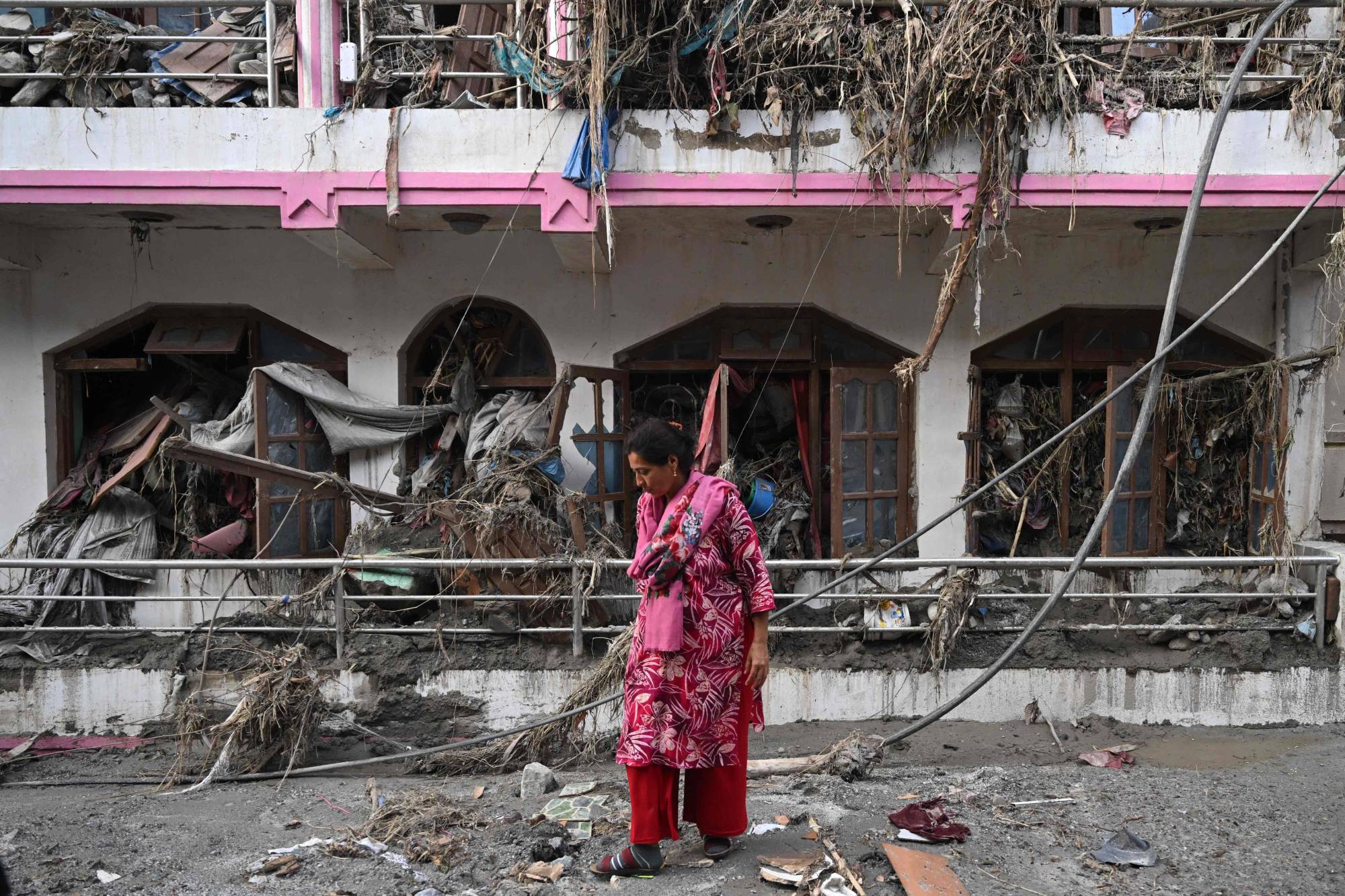Bir kadın, 28 Ağustos’ta Nepal’in Nuwakot bölgesinde enkazların arasında eşyalarını arıyor (AFP).