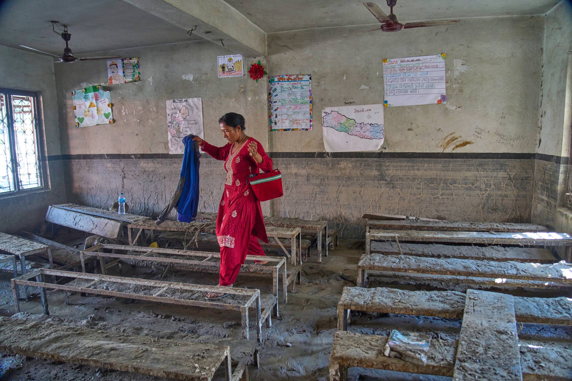 Bir anne, Nepal’de sellerde zarar gören bir sınıfta çocuğuna ait eşyaları arıyor, (AP)