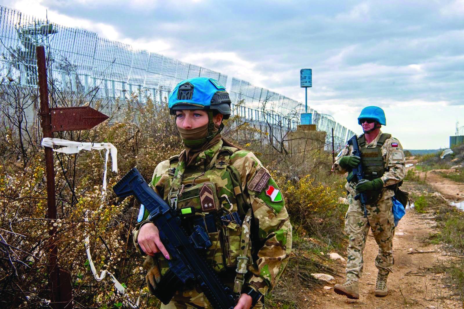 BM Lübnan Geçici Barış Gücü (UNIFIL) askerleri, Lübnan'ın güneyinde İsrail sınırındaki tel örgüler yakınında yaya devriye geziyor (UNIFIL)