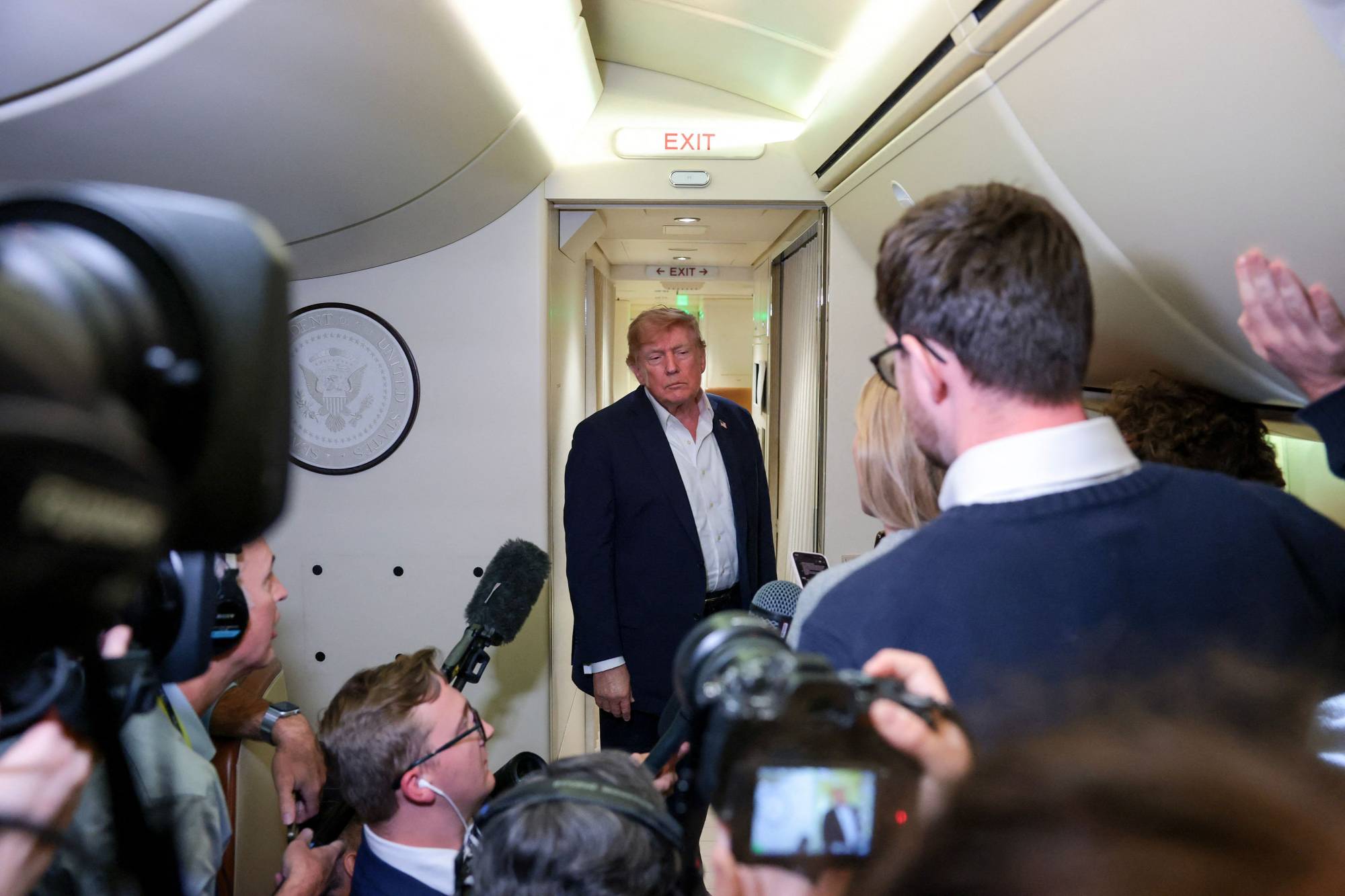 ABD Başkanı Donald Trump pazar günü Air Force One uçağında gazetecilere açıklamalarda bulunuyor (AFP)