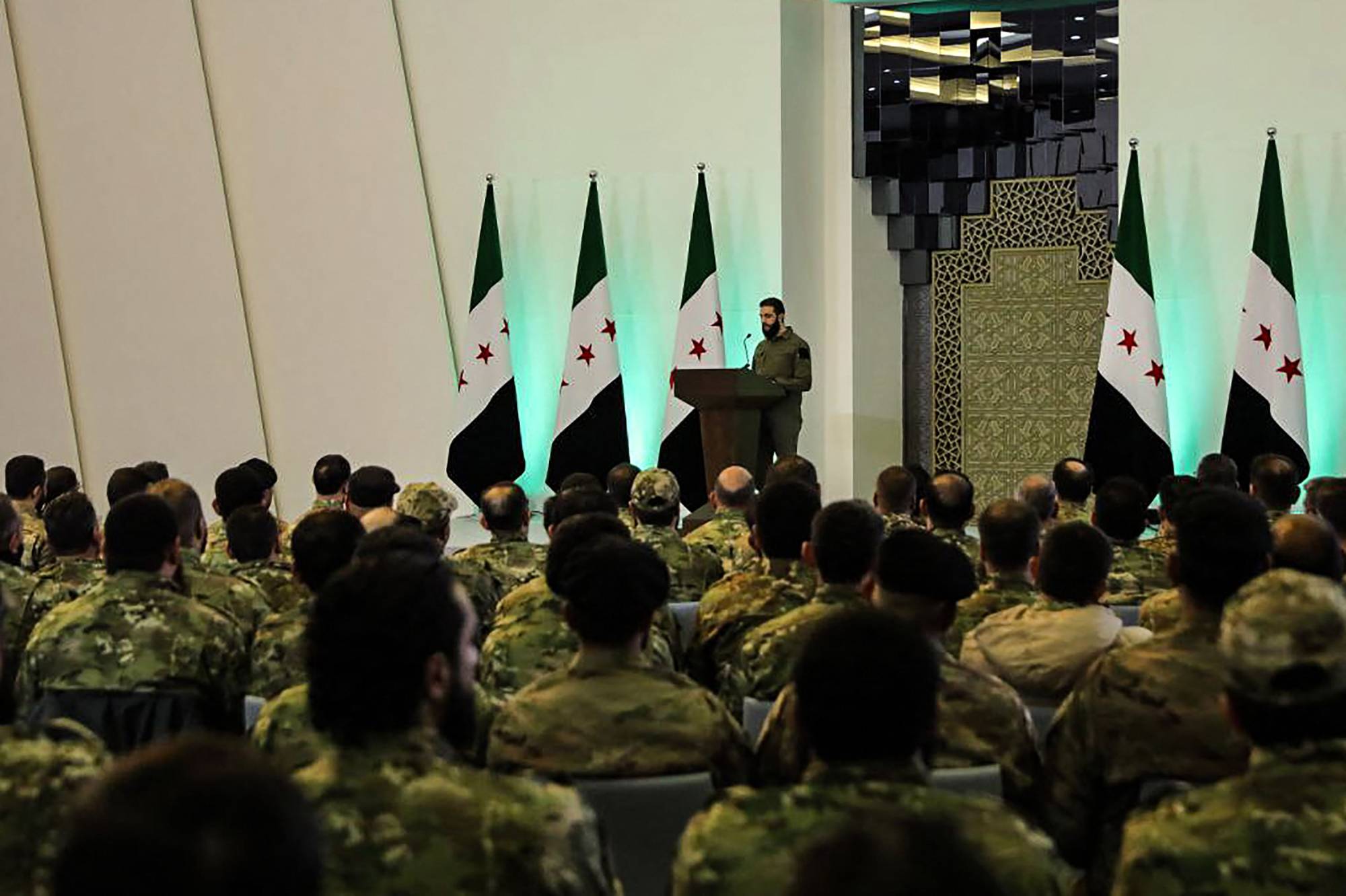 Suriye Cumhurbaşkanı Ahmed El-Şera, Suriye Devrimi’nin zaferinin ilan edildiği konferansta, Askeri Operasyonlar İdaresi’ne bağlı çeşitli grupların geniş katılımıyla 29 Ocak 2025 tarihinde (AFP)
