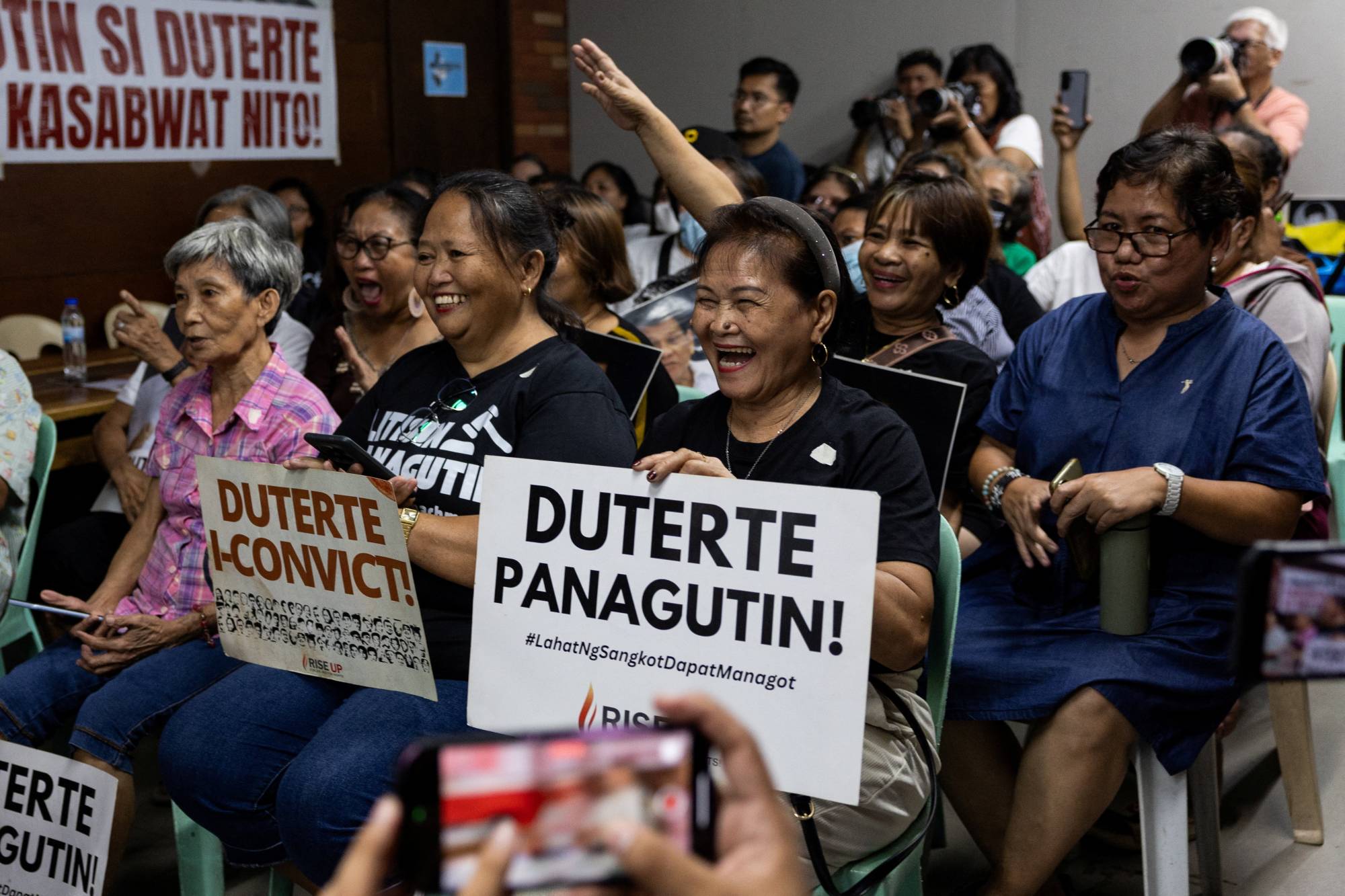 Uyuşturucuyla mücadele savaşı mağdurlarının yakınları, eski Filipinler Devlet Başkanı Rodrigo Duterte'nin Uluslararası Ceza Mahkemesi'ndeki duruşmasının canlı yayınını izlerken slogan attı; Filipinler'in Quezon kentinde, 16 Eylül 2026 (Reuters).