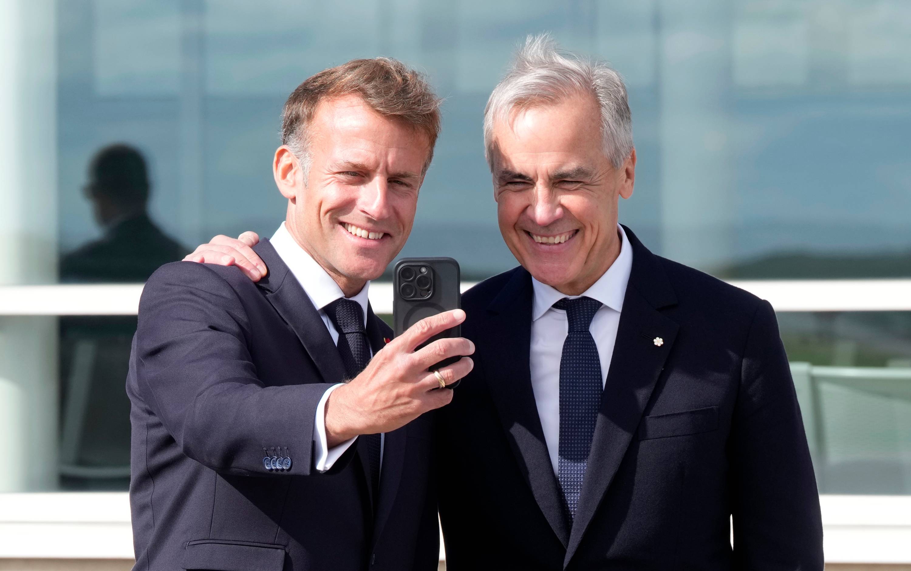 Fransa Cumhurbaşkanı Emmanuel Macron, Saint-Pierre ve Miquelon’da yaptığı konuşmanın ardından Kanada Başbakanı Mark Carney ile selfie çekerken. (AP)