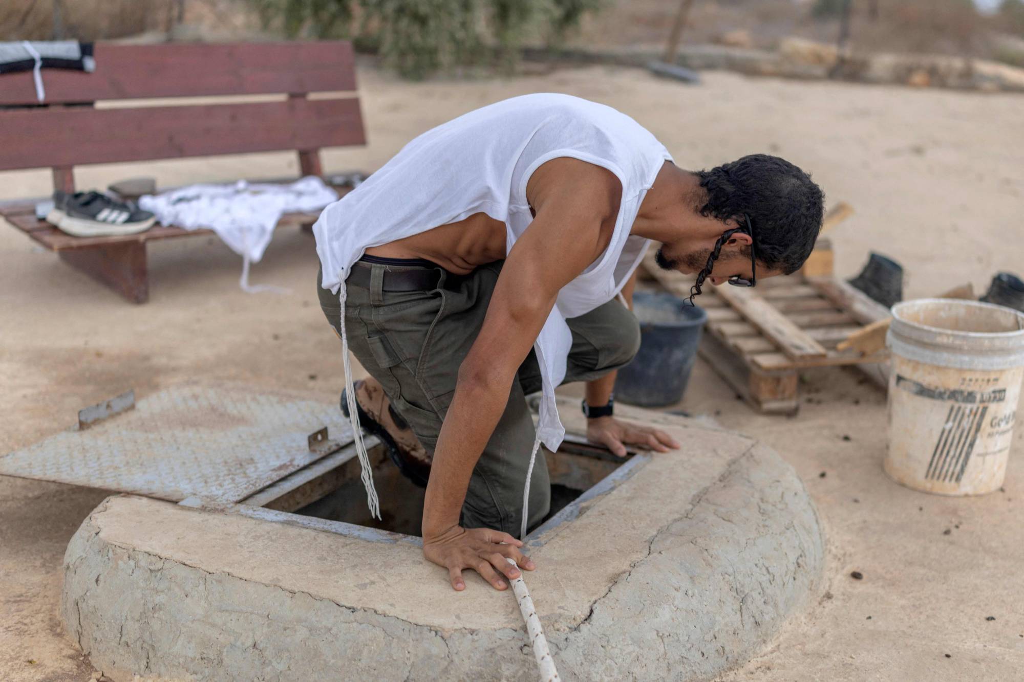 İsrail yerleşimcisi, bugün işgal altındaki Batı Şeria’da Cenin kenti yakınlarındaki Ganim yerleşiminde Filistinlilere ait bir su deposuna giriyor. (AFP)