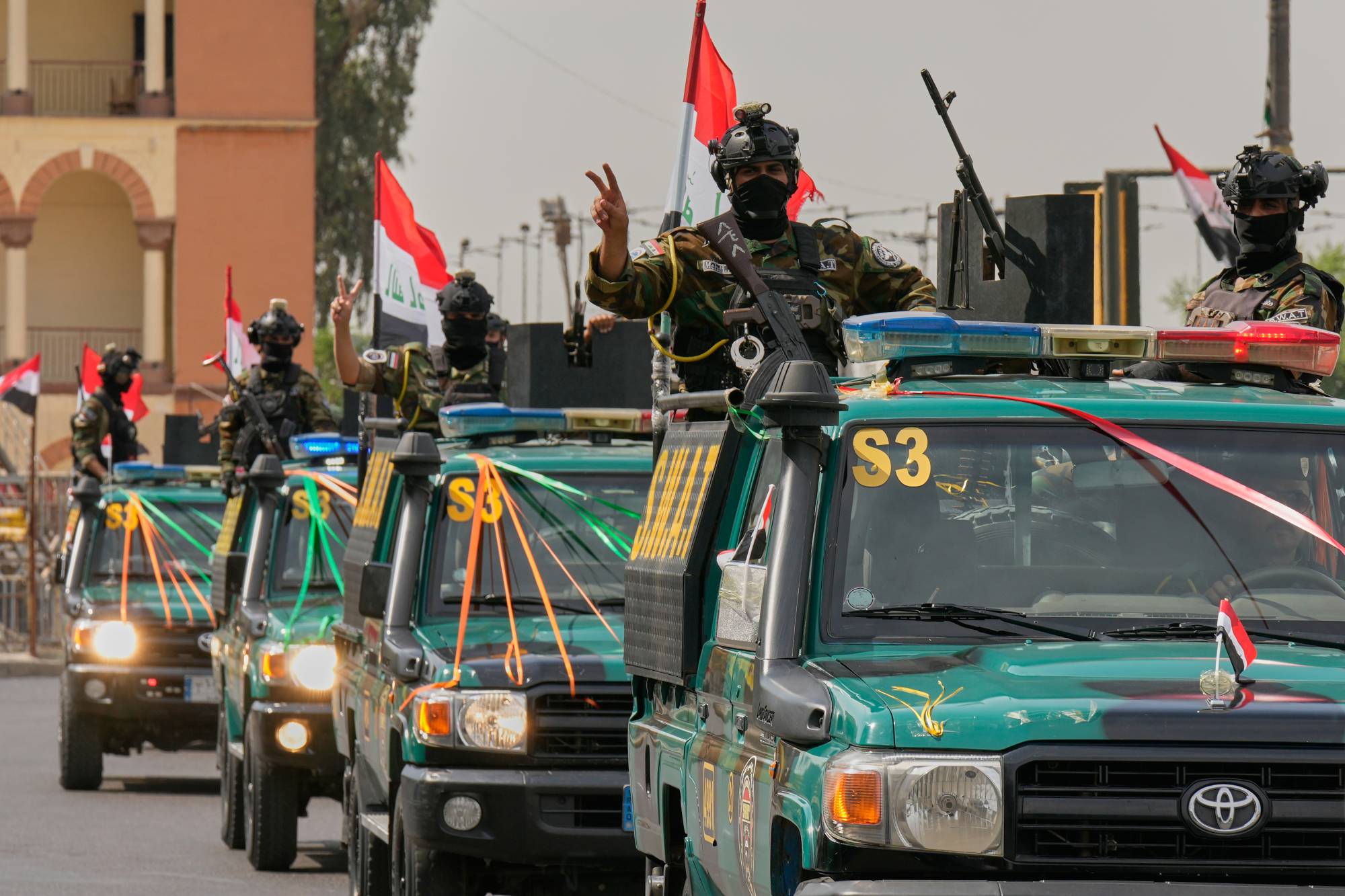 Irak güvenlik güçleri mensupları, ABD güçlerinin Irak’tan tamamen çekilmesini kutlamak amacıyla bugün Bağdat’ta düzenlenen konvoya katılırken zafer işareti yaptı. (AP)