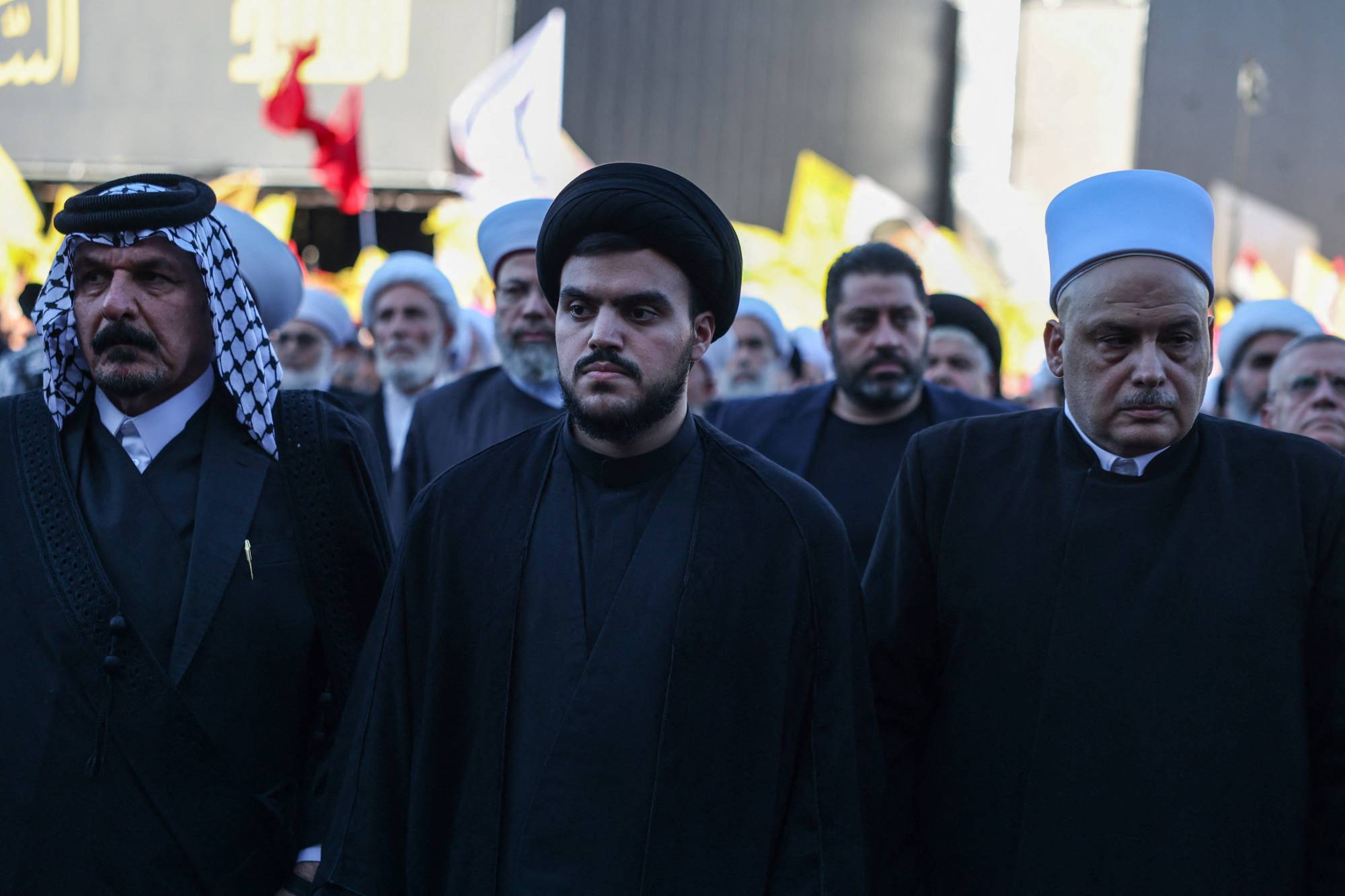 Hasan Nasrallah’ın oğlu Muhammed Mehdi, babasının öldürülmesinin ikinci yıl dönümü anma töreninde iki davetlinin arasında, Beyrut’un güney banliyölerinde (Reuters)