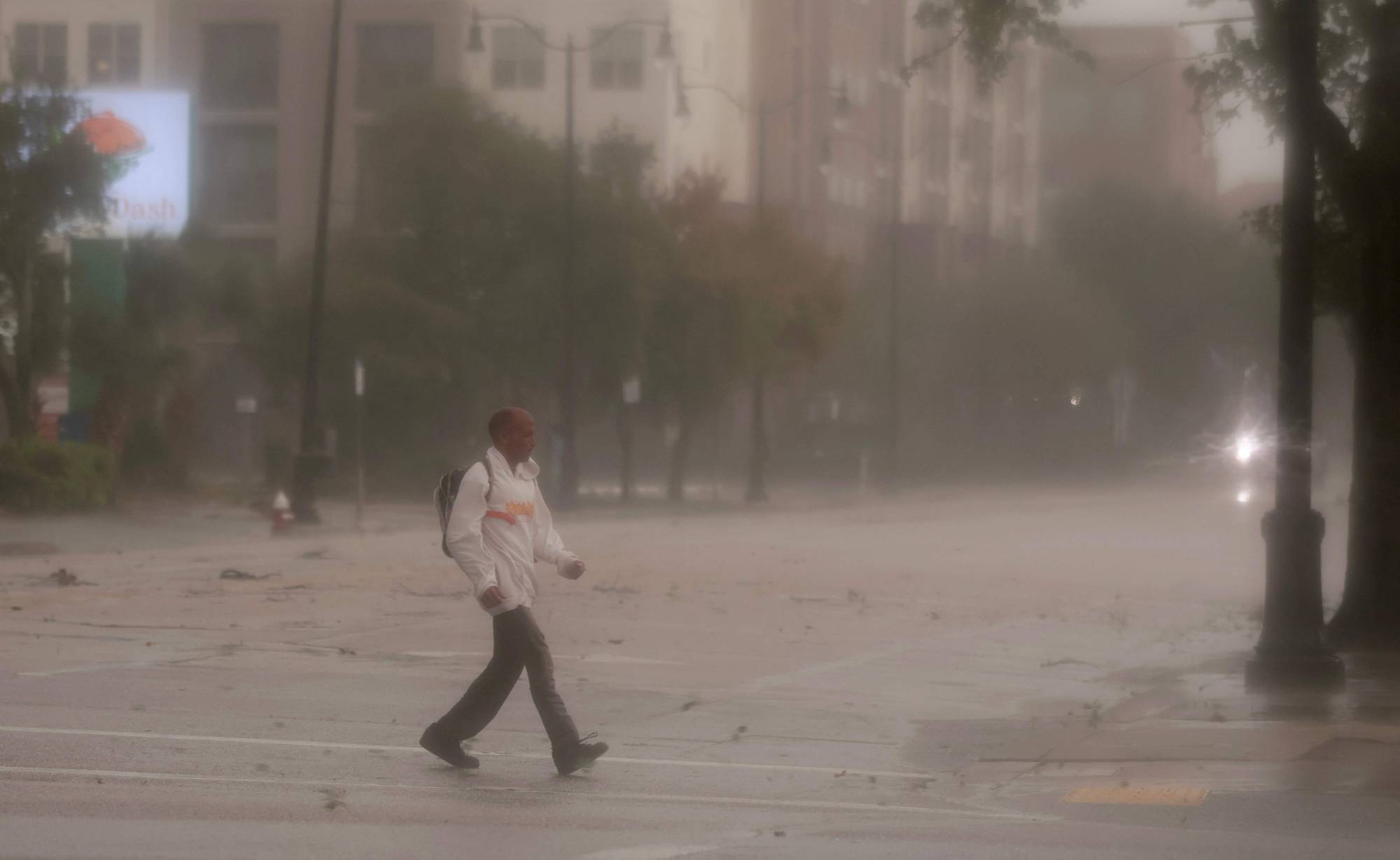  Florida eyaletinin Pensacola kentinde ‘Isaías’ kasırgası sırasında rüzgâr ve yağmur altında yürüyen bir kişi (AFP)