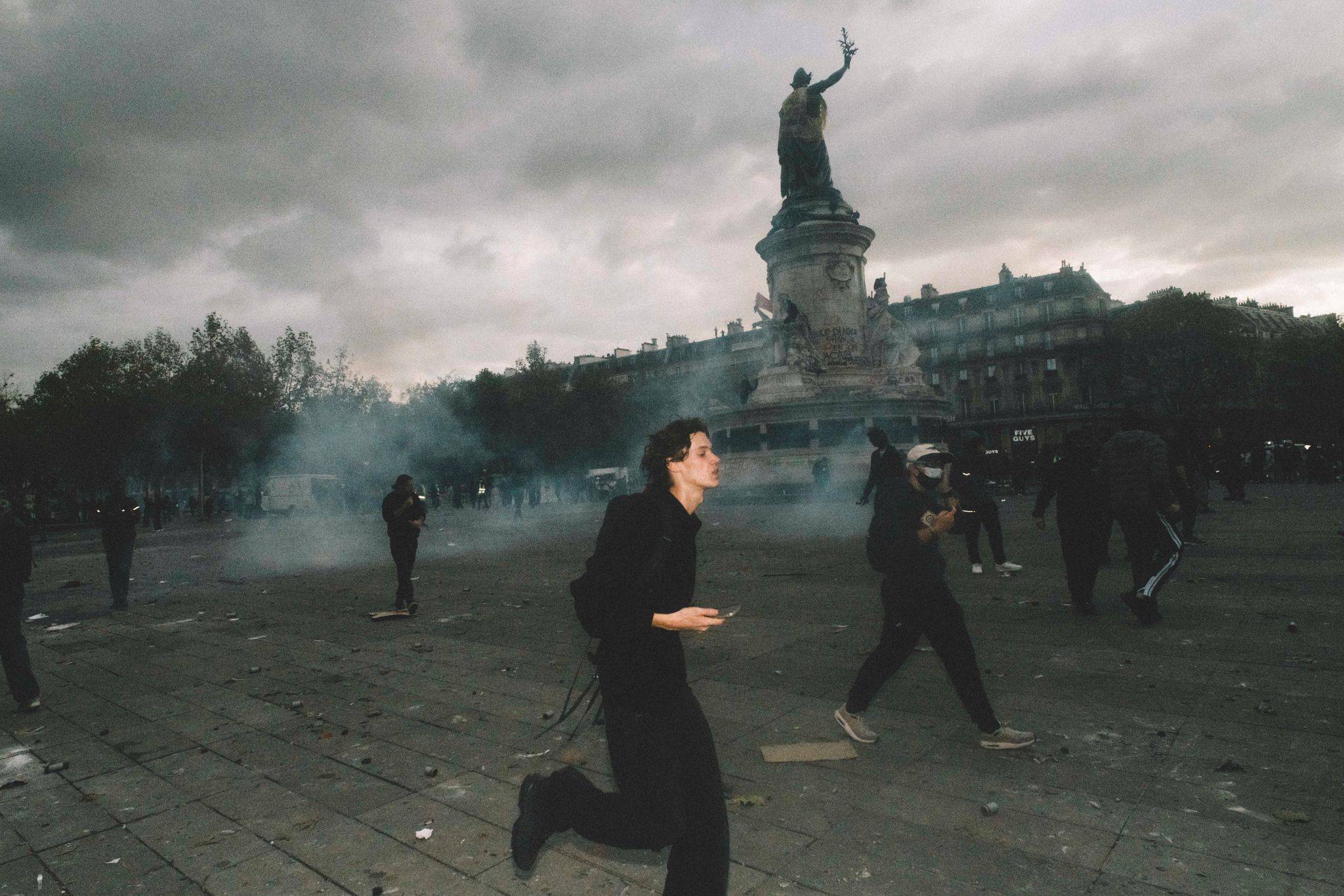 Paris’teki Cumhuriyet Meydanı’nda biber gazından göz gözü görmediği anlarda göstericiler kaçışırken görüntülendi. (DPA)