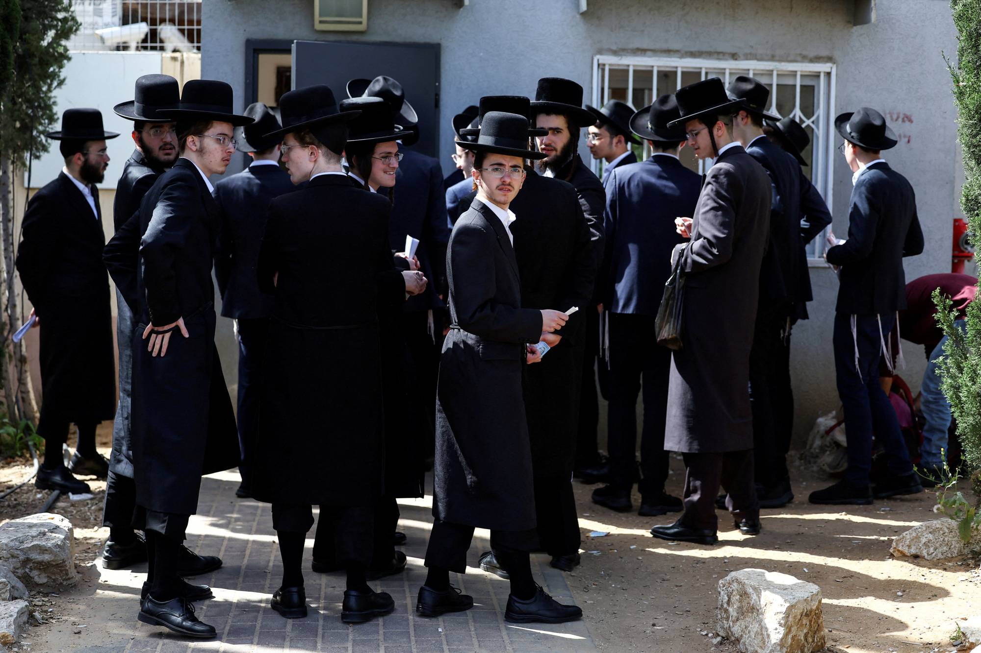 İsrail’deki Kiryat Ono askerlik şubesinde, zorunlu askerlik hizmetinden muafiyet işlemleri için sıraya giren Haredi Yahudiler, mart ayında (Reuters).