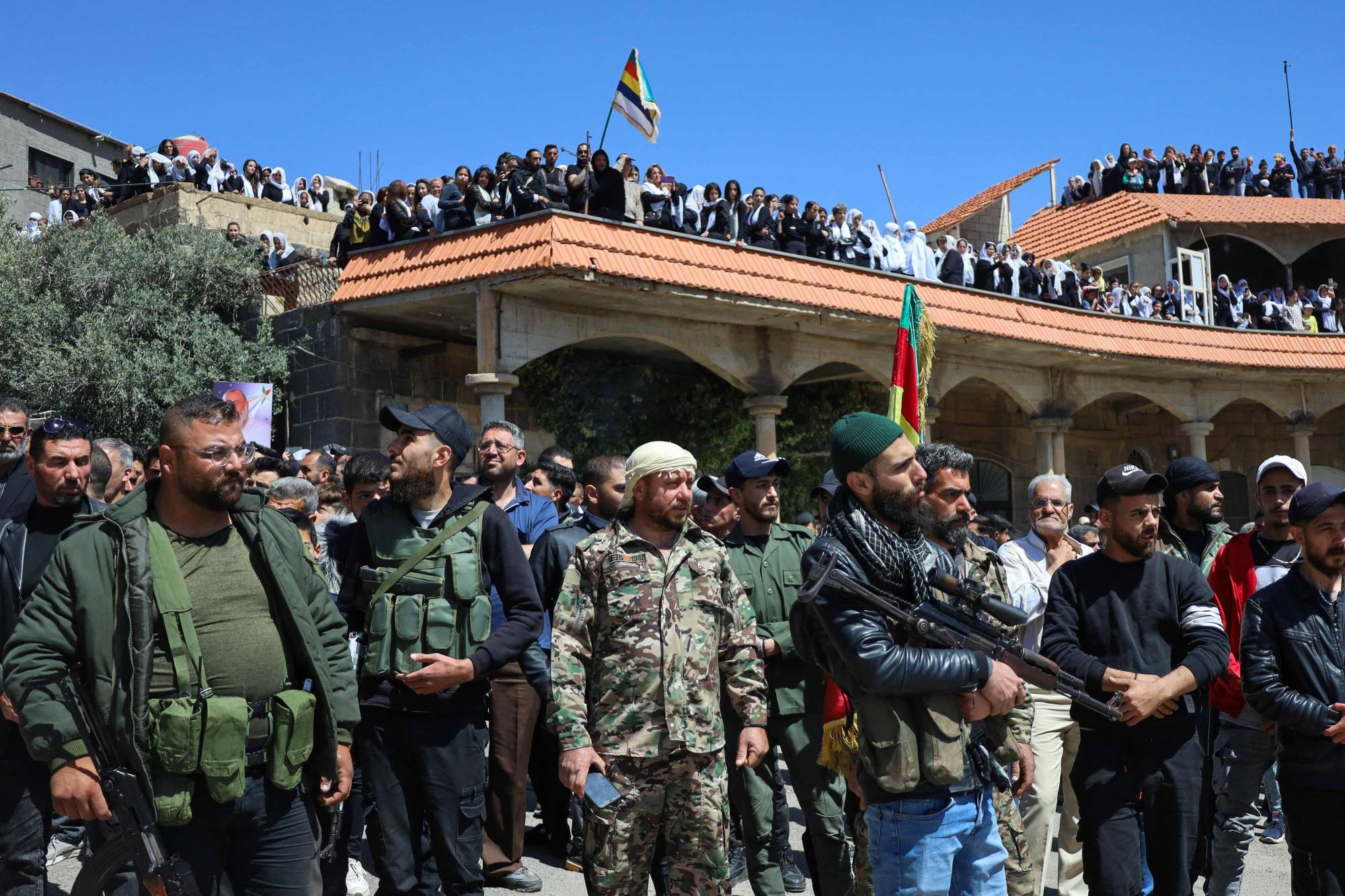Suriye’nin Süveyda kentinde, hükümet güçleriyle yaşanan çatışmalarda hayatını kaybedenlerin cenaze törenine cumartesi günü katılan silahlı Dürzi militanlar (AFP).