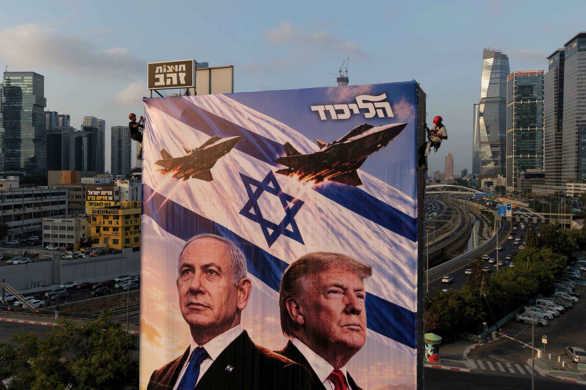 Tel Aviv’de, İsrail Başbakanı Binyamin Netanyahu’yu ABD Başkanı Donald Trump ve savaş uçaklarıyla birlikte gösteren, Likud Partisi’ne ait dev seçim afişi asılıyor. (AP)