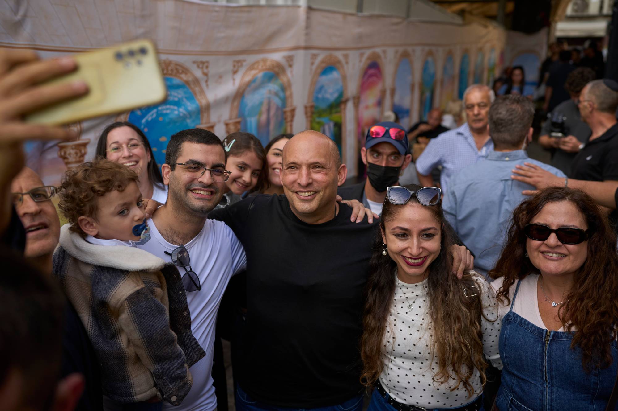  İsrail’in eski Başbakanı Naftali Bennett, Kudüs’teki Mahane Yehuda pazarındaki bir restoranda destekçileriyle fotoğraf çekiliyor. (AP)