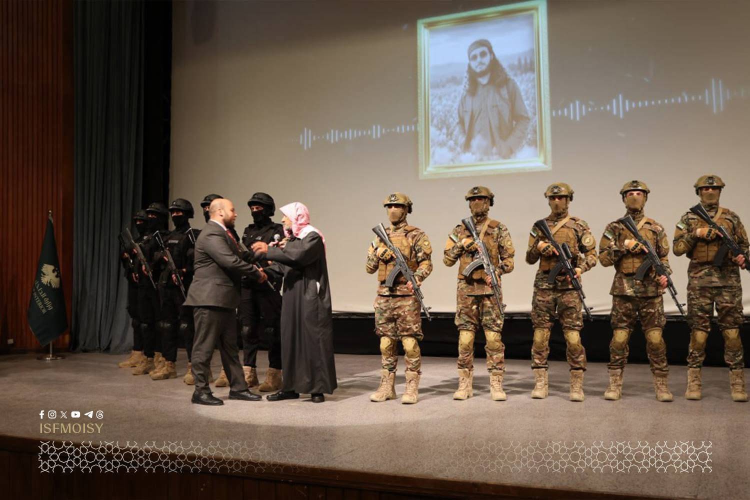 Esed rejimine karşı Hama cephelerinde yürütülen operasyonları sırasında hayatını kaybeden savaşçı Muhammed Subeyha’nın babasına, oğlunun fedakârlıkları dolayısıyla onur plaketi takdim edildi. (İç kurtuluş Güvenlik Güçleri)