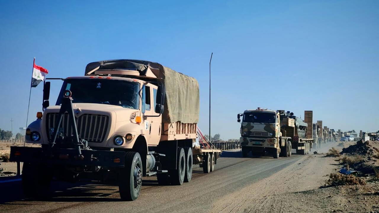 Suriye sınırında hareket hâlindeki Irak’a ait kamyonlar ve askerî araçlar (AFP).