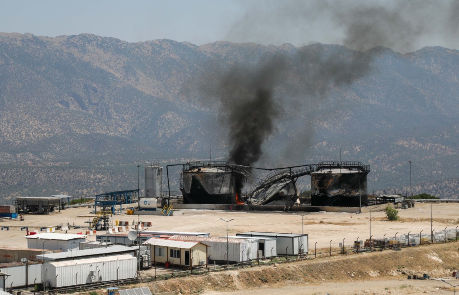 IKBY’deki Kürt şehri Dohuk yakınlarındaki Şamanki bölgesine düzenlenen SİHA saldırısının ardından, Sarsang Petrol Sahası’ndaki hasarlı petrol tesisinden yükselen dumanlar, 17 Temmuz 2025 (AFP)