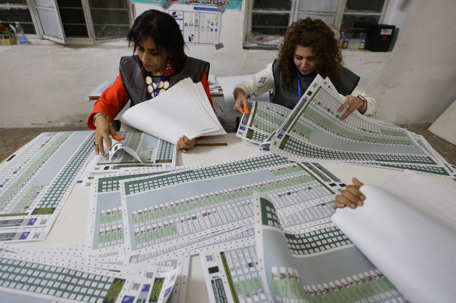 Bağdat'ın doğusundaki el-Muhendisin bölgesinde Irak genel seçimlerinde sandıkların kapanmasının ardından oyların sayıldığı bir seçim merkezi, 11 Kasım 2025 (AFP)