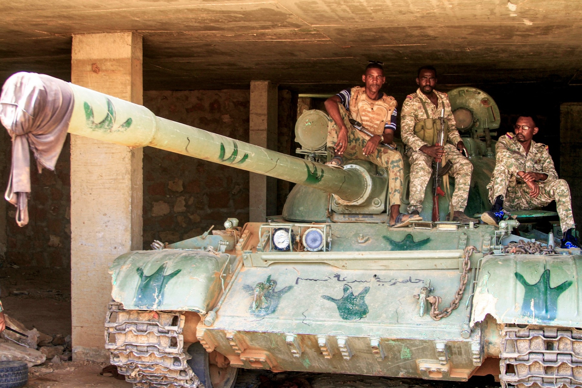 Sudan’ın başkenti Omdurman'ın ikiz şehri Salha’da HDK tarafından kullanılan bir üssü ele geçirdikten sonra hareketsiz bir tankın üzerine oturan Sudanlı askerler, 26 Mayıs 2025 (AFP)