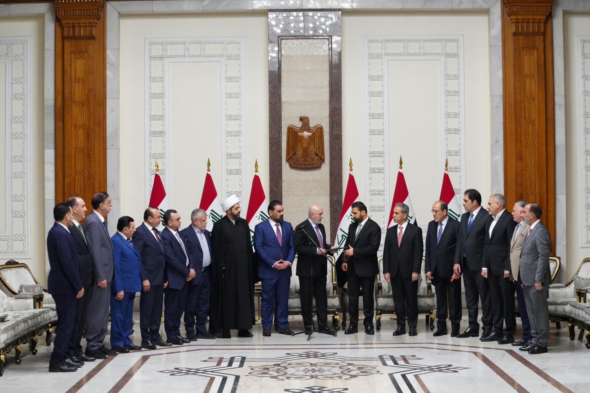 Irak Cumhurbaşkanı Nizar Amedi ve Başbakan adayı Ali Zeydi, Bağdat'ta düzenlenen ve Zeydi'nin yeni hükümeti kurmakla görevlendirildiği törende siyasi figürlerle birlikte duruyor, 27 Nisan 2026 (Reuters)