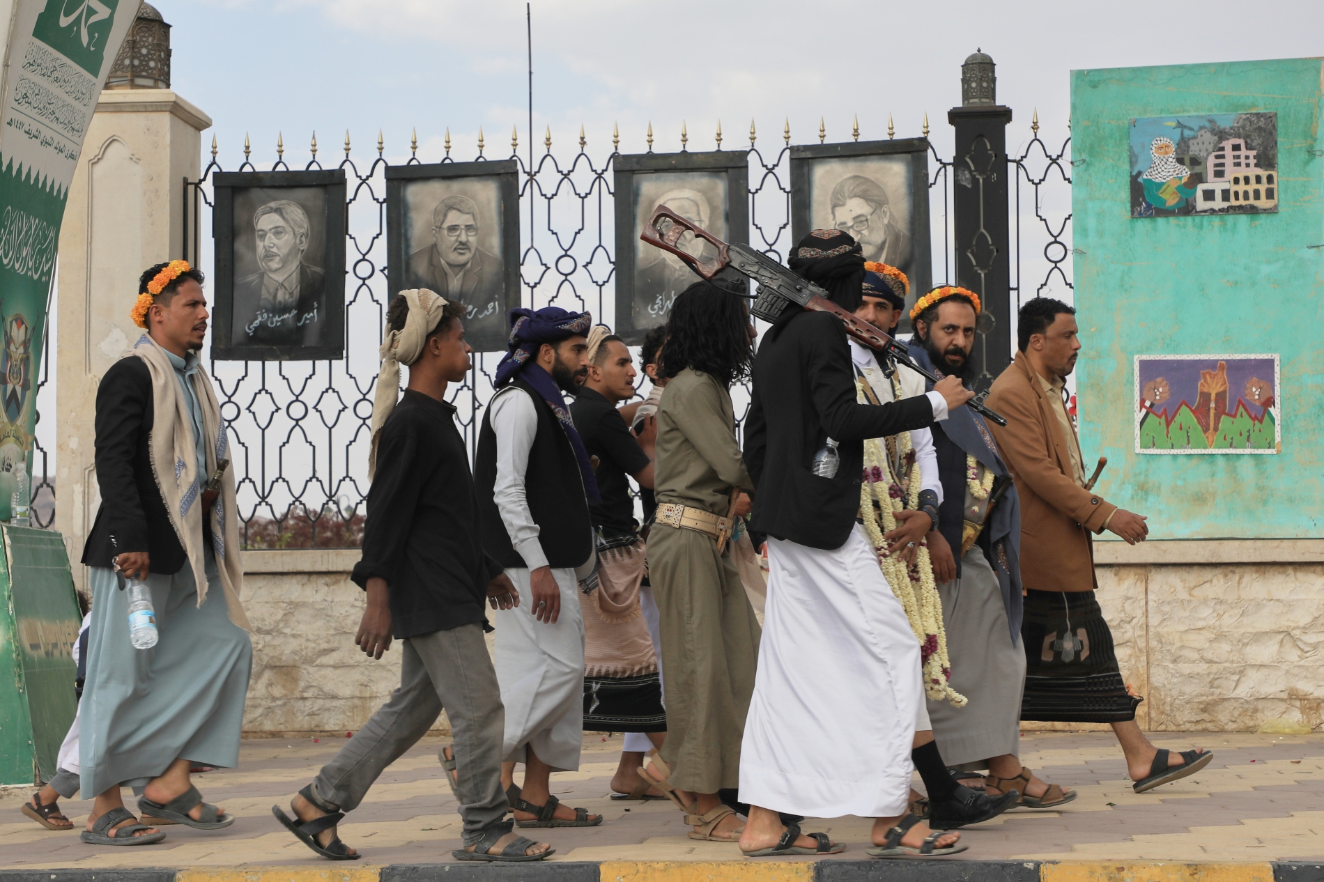 Yemen’in Sana şehrinde İsrail saldırılarında hayatını kaybeden bazı önde gelen İranlı din alimlerinin posterlerinin önünde yürüyen Husi destekçileri, 13 Temmuz 2026 (AP)
