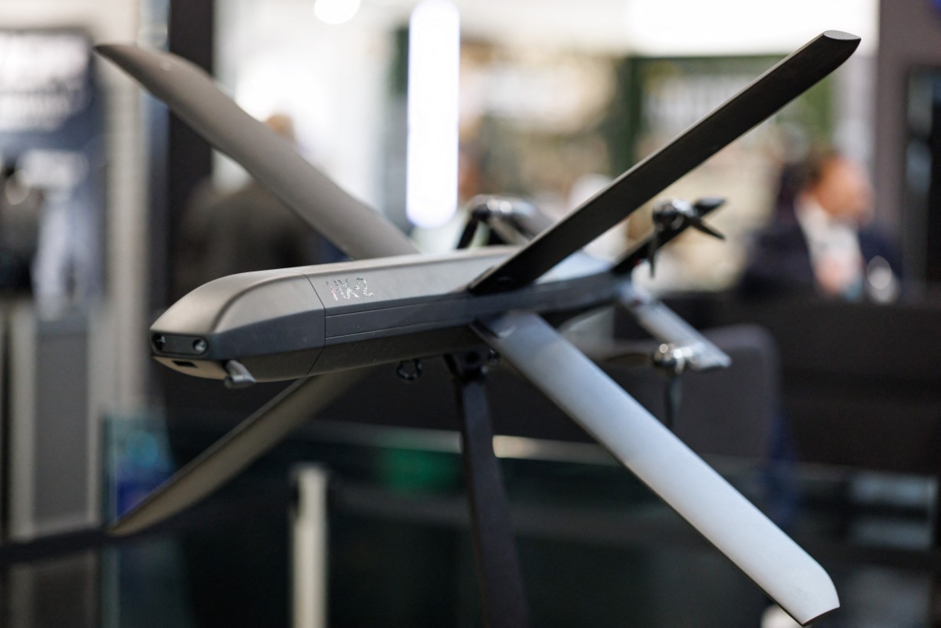 Alman savunma girişim şirketi Helsing'in standında sergilenen HX-2 AI Strike Dronu. Şirket, askeri ekipmanların kapasitesini güçlendirmek amacıyla yapay zeka ve yazılım geliştirme üzerinde çalışıyor (AFP)