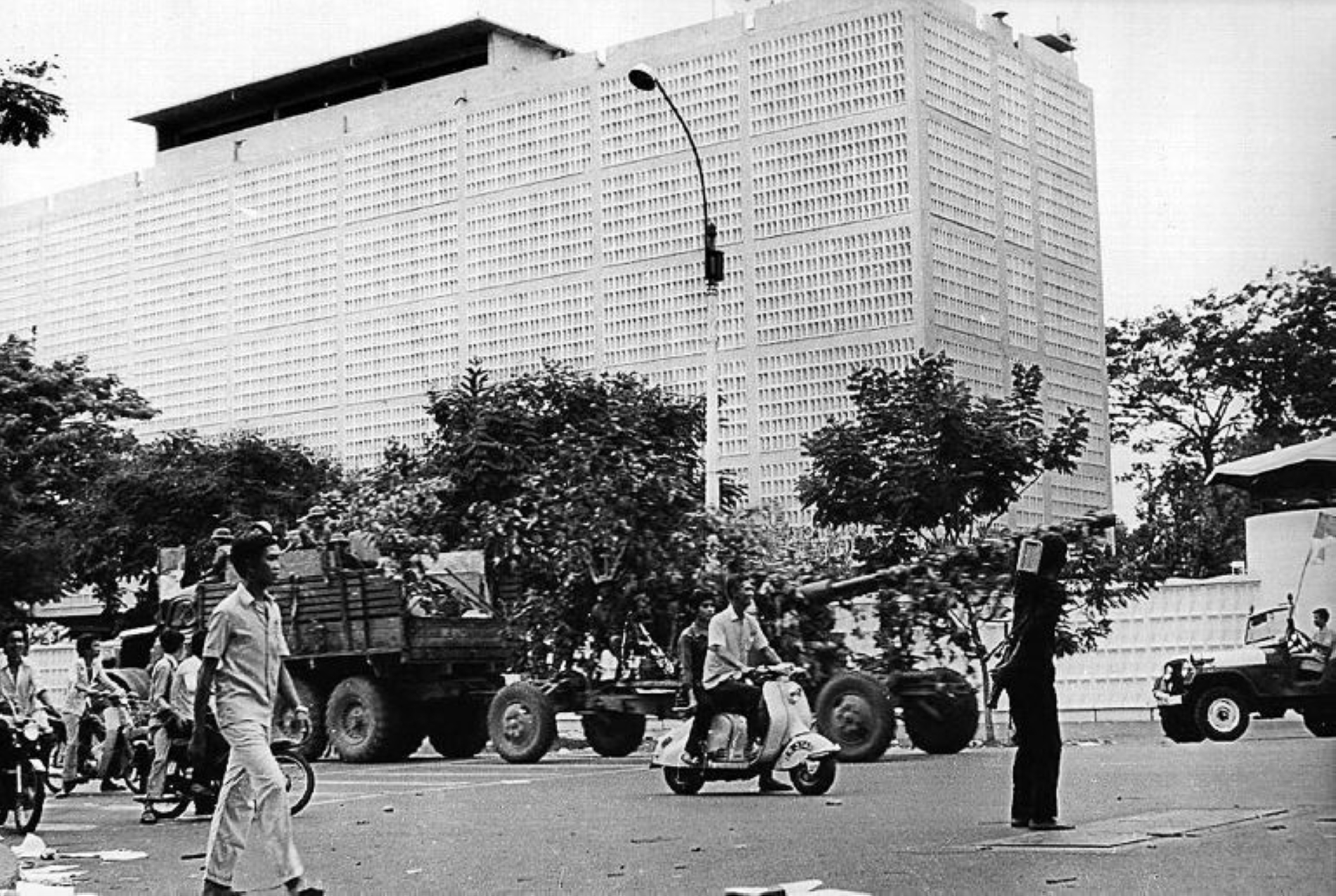 30 Nisan 1975 tarihli bir fotoğraf, Kuzey Vietnam ordusuna ait bir kamyonu, aynı gün komünist güçlerin eline geçen ve Vietnam Savaşı'nın sonunu işaret eden Saigon'daki terk edilmiş ABD büyükelçiliğinin önünden bir topu çekerken gösteriyor (Vietnam Haber Ajansı/AFP)