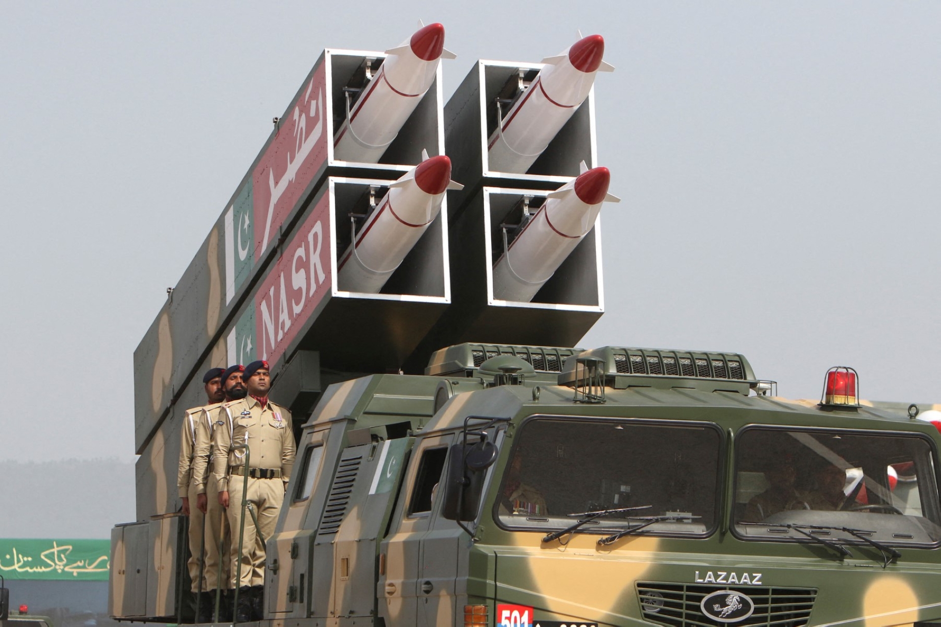 İslamabad'da düzenlenen "Pakistan Günü" geçit töreninde "Nasr" füzeleri taşıyan askeri aracın üzerinde duran Pakistan askerleri, 23 Mart 2022 (AFP)