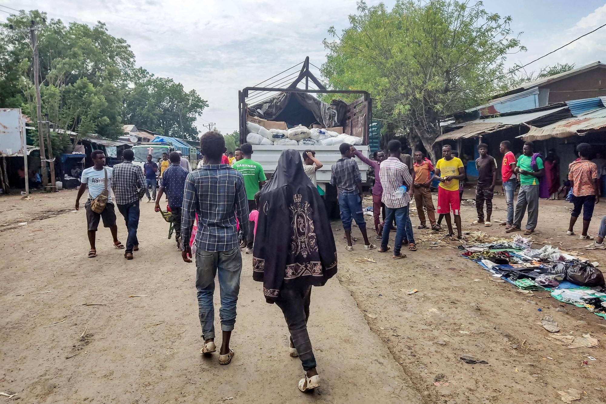 Sudanlılar kuzeybatı Etiyopya'daki Metema şehrinde bir cadde boyunca yürüyor (AFP)