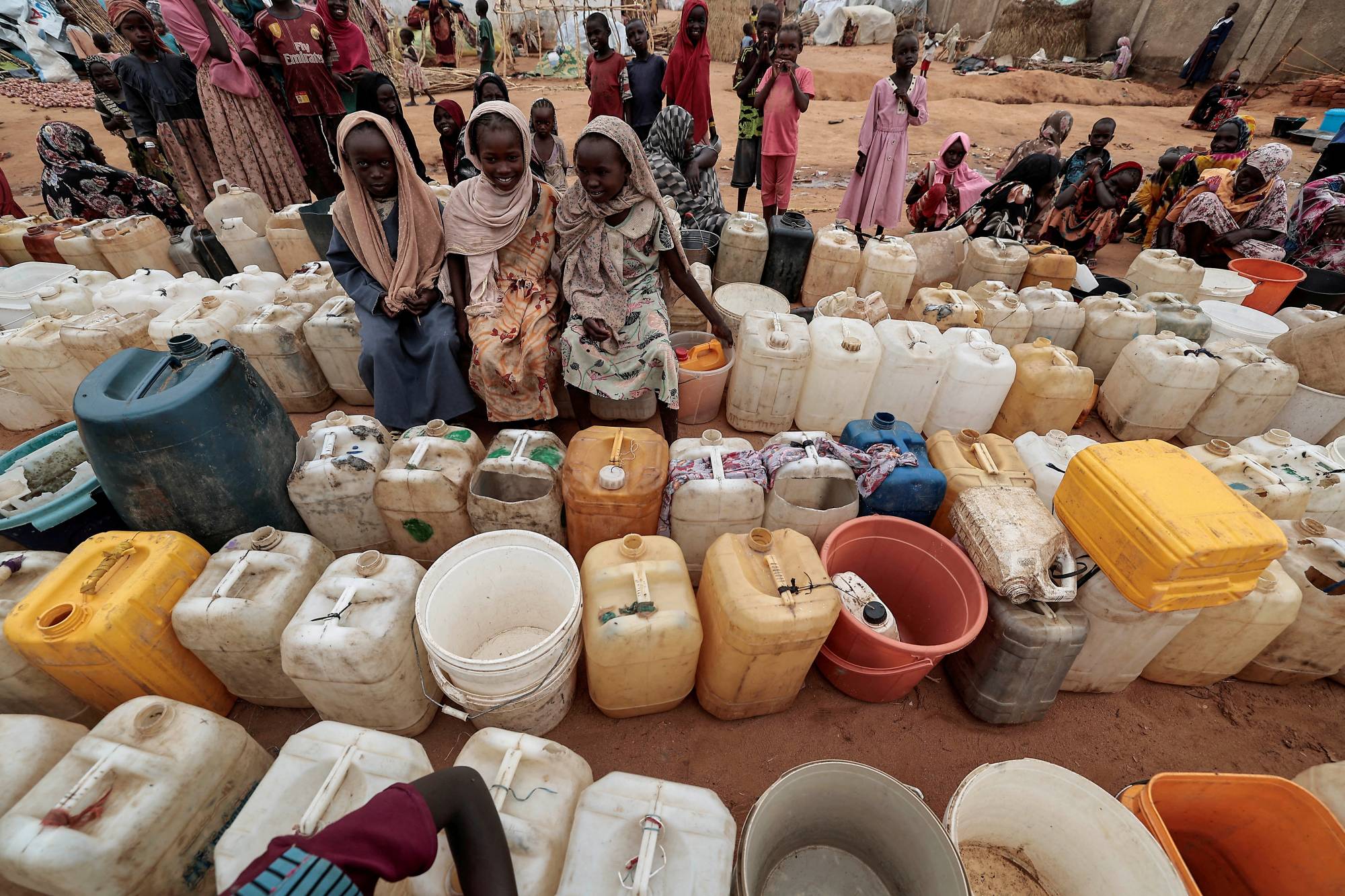 Sudan'ın Darfur bölgesindeki Cuneyna’daki çatışmalardan kaçan Sudanlı kızlar, Çad'ın Adre kentindeki su noktasında sıraya girdi (Reuters)