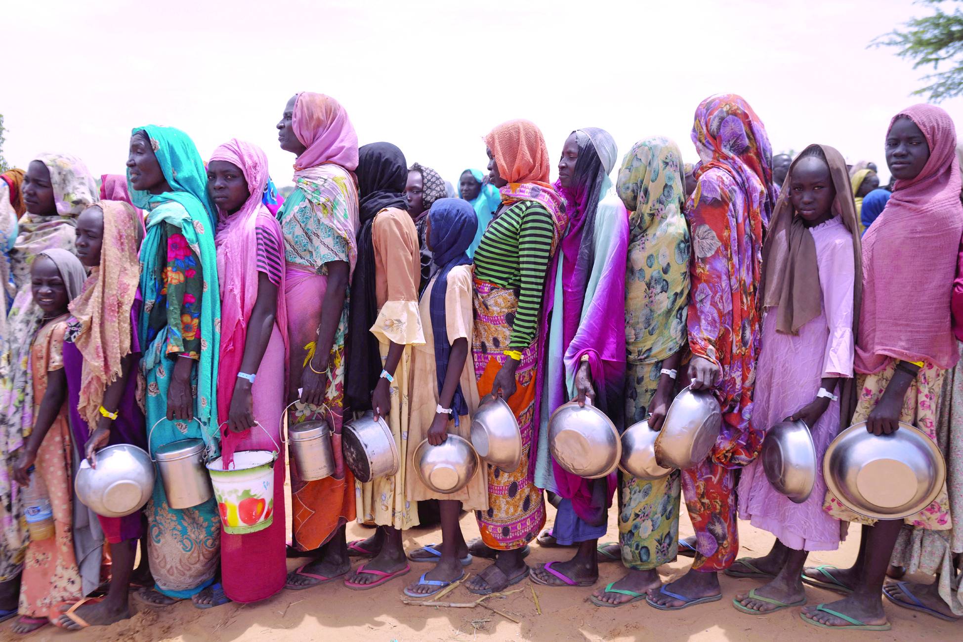 Sudanlı kadınlar, Çad'ın Adre kentinde Uluslararası Kızılhaç Komitesi’nden (ICRC) yardım almak için sırada bekliyor. (Reuters) 