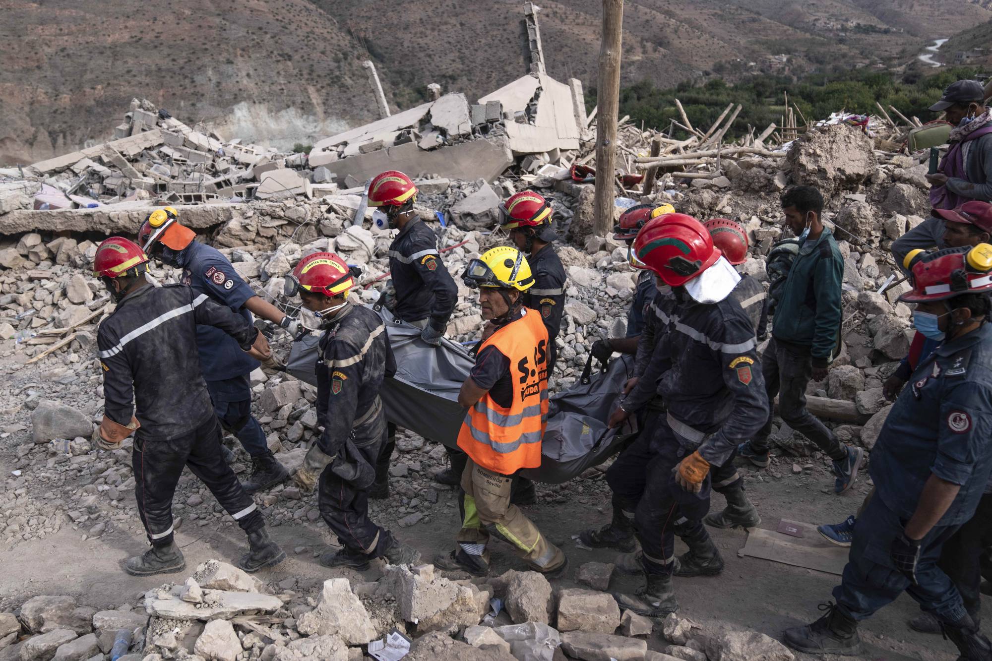 Fotoğraf altı: Bir kurtarma ekibi, 12 Eylül 2023 salı günü Fas’ın Marakeş dışındaki Imi Natala beldesinde depremde ölen bir kadının cesedini çıkardı (AP)