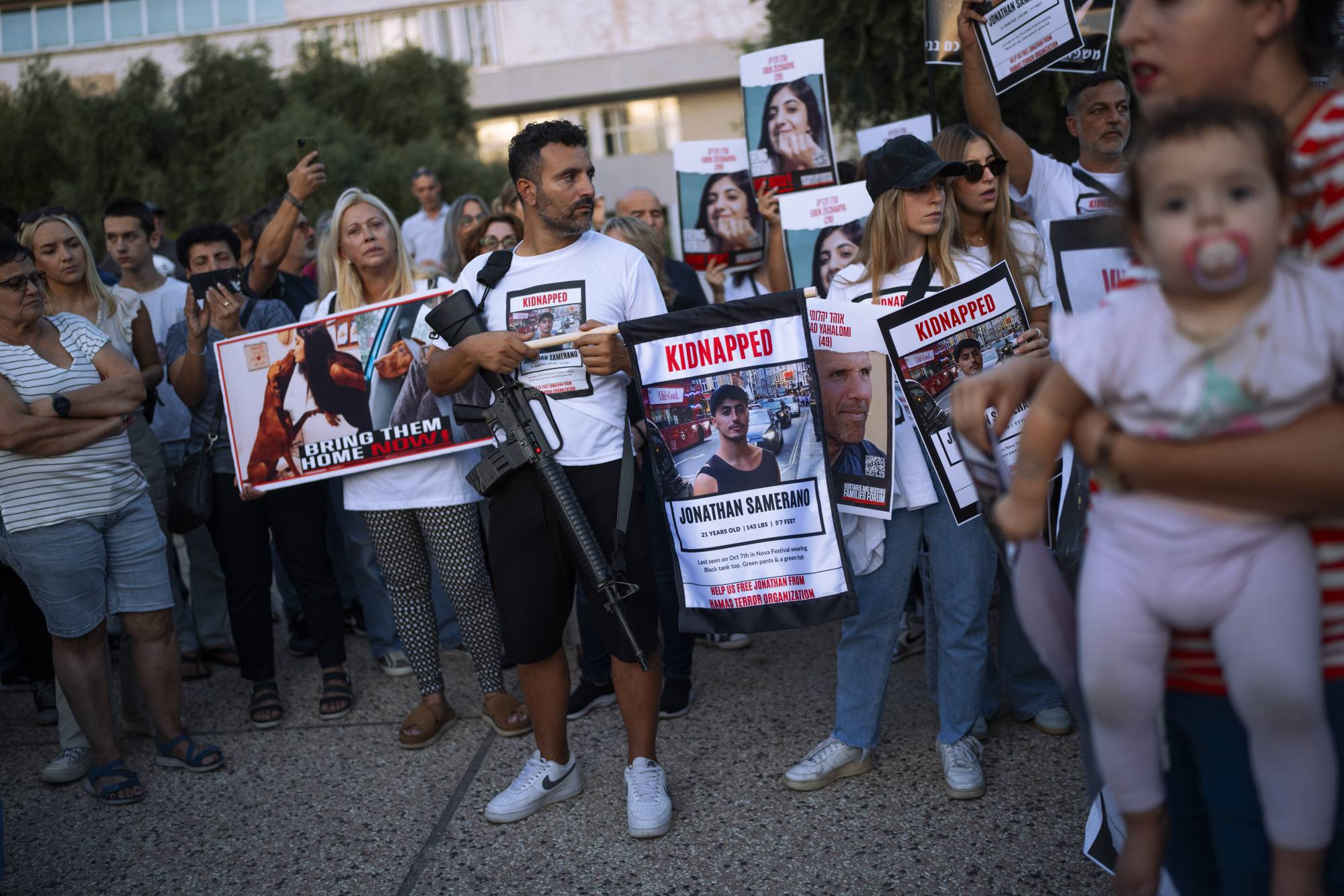 Hamas tarafından kaçırılan sivillerin aileleri, dün Tel Aviv’de onların geri dönüşü çağrısı yaptıkları bir protesto sırasında fotoğraflarını taşıyor (AP)