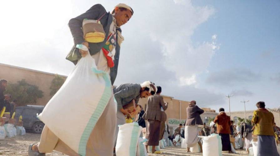 Amran ilinde yaşayan bir Yemenli, bir yardım kuruluşu tarafından sağlanan gıda yardımını alıyor (EPA)