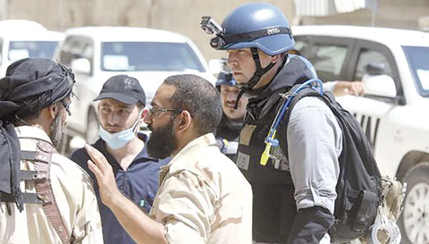 فريق المفتشين الدوليين يلتقون عناصر من الجيش السوري الحر في دمشق أمس خلال تفقدهم موقعا استخدمت فيه أسلحة كيماوية (رويترز)
