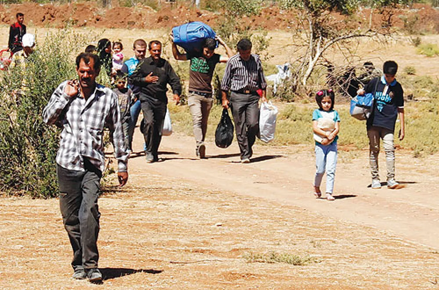 لاجئون سوريون يقطعون الحدود متجهين نحو تركيا أمس (رويترز)