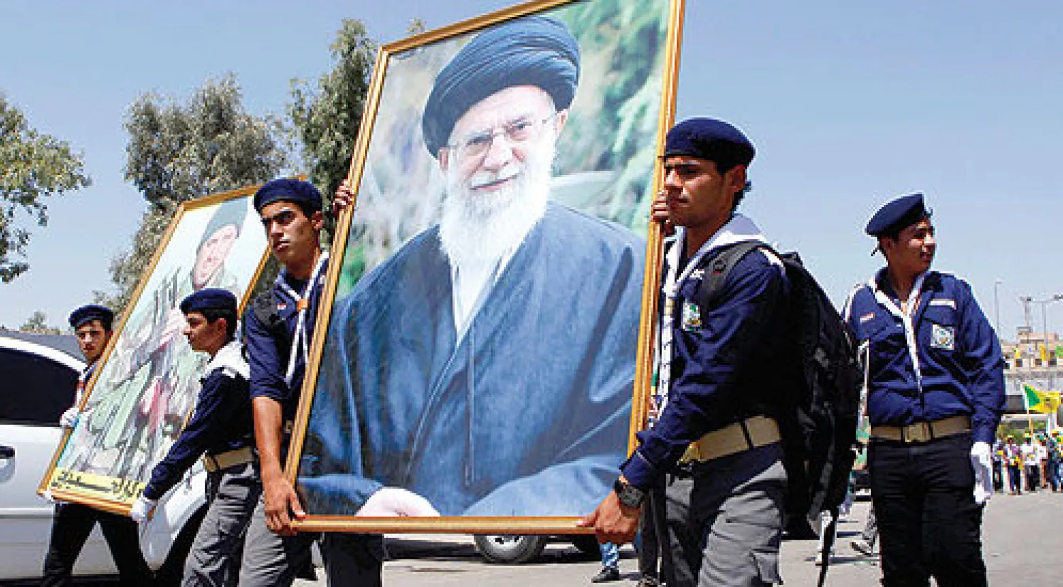 عناصر من «حزب الله العراقي» يحملون صورة للمرشد الأعلى الإيراني علي خامنئي خلال استعراض في بغداد أوائل الشهر الحالي (أ.ب)
